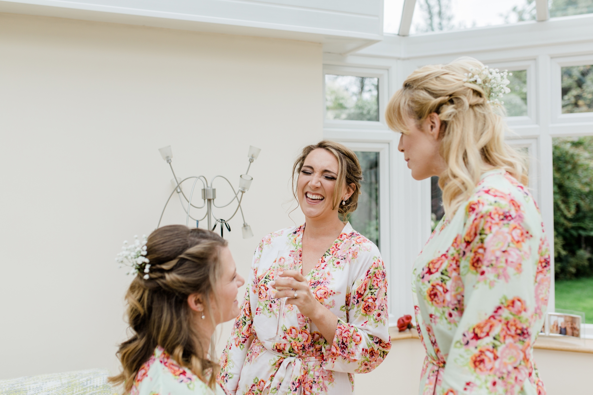 bride laughing with floral robe on