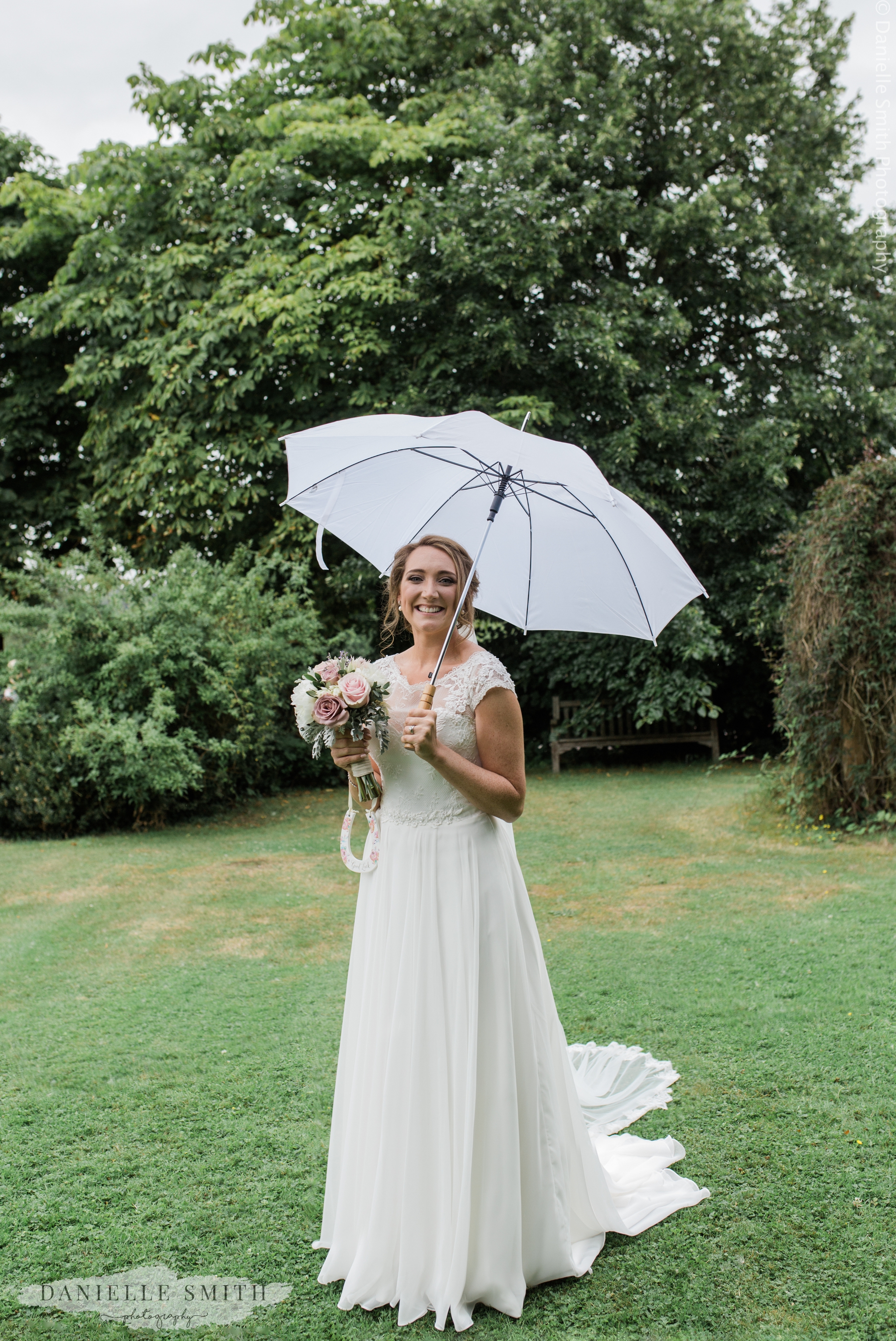 bride standing under umbrella