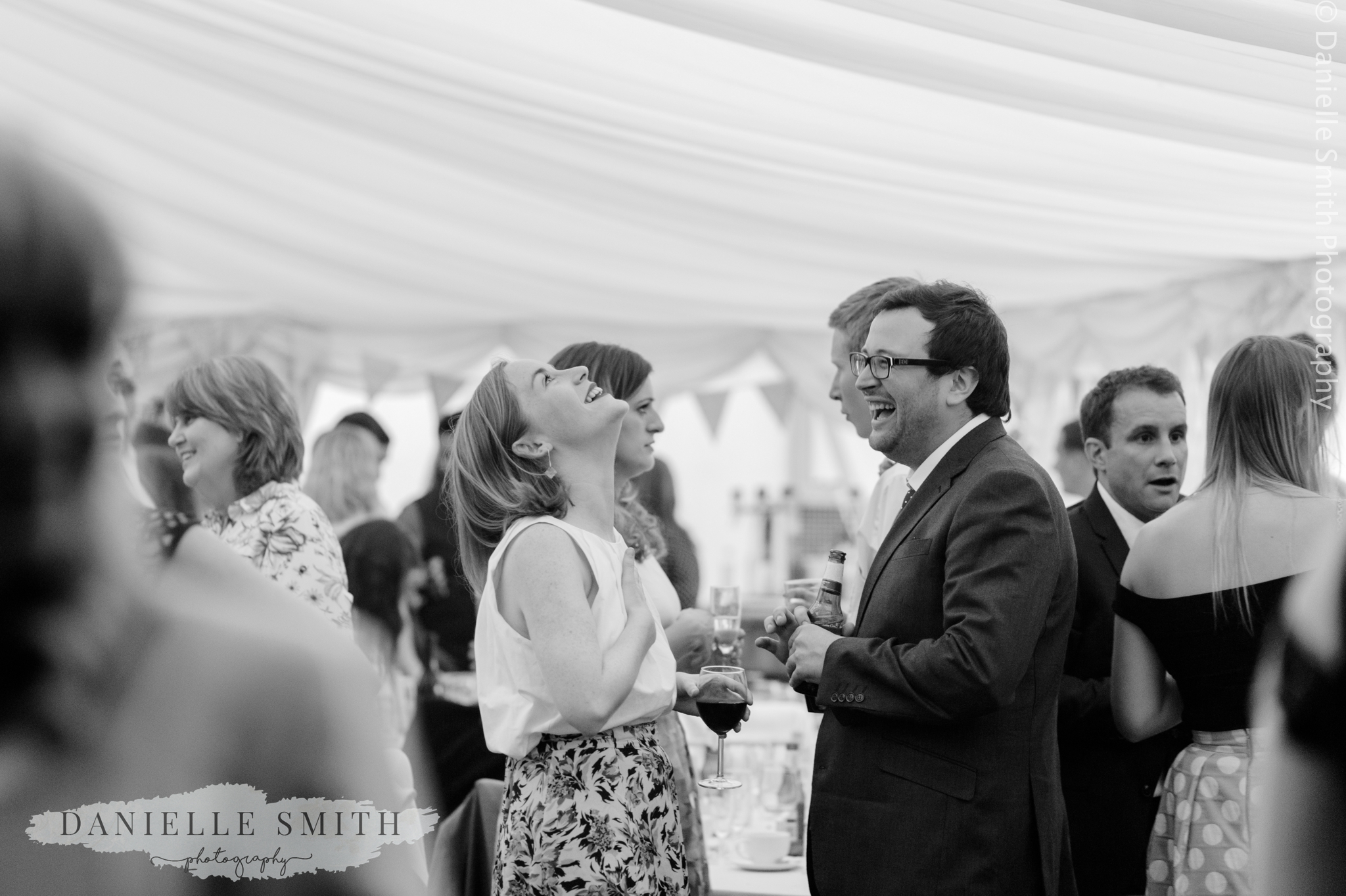 wedding guests laughing - relaxed marquee wedding