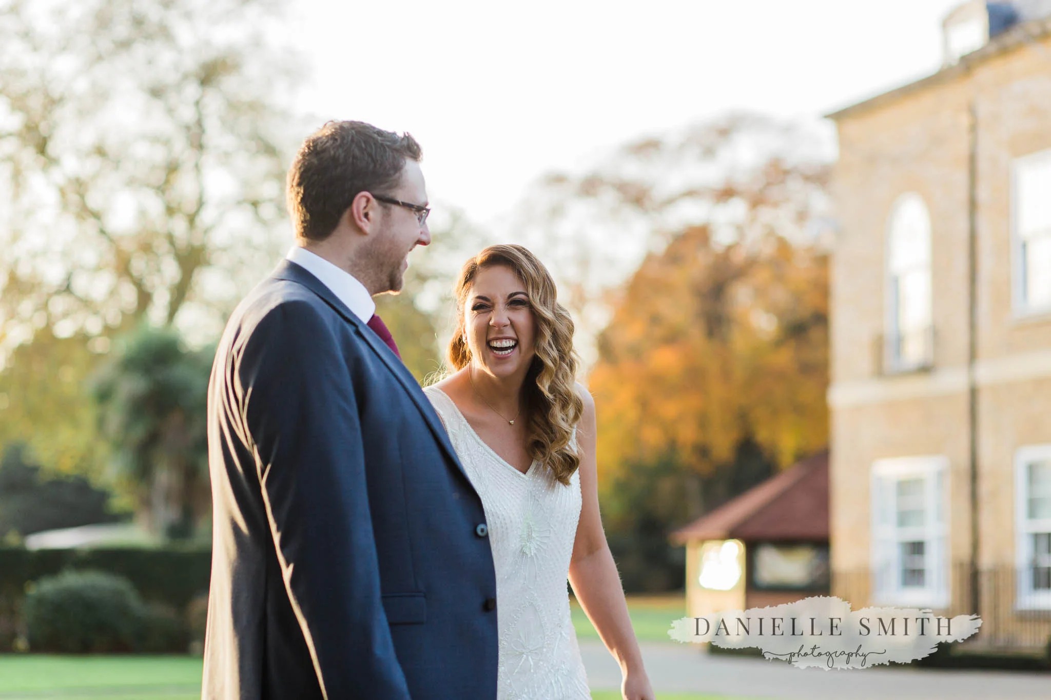 bride and groom walking and laughing - orsett hall wedding photographer