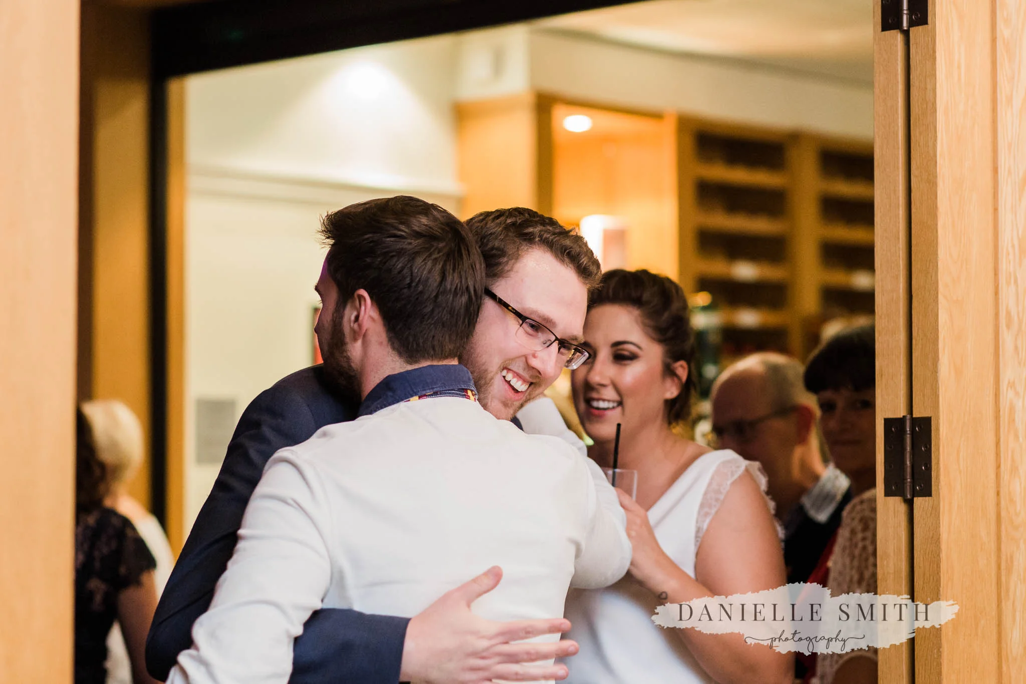 groom hugging wedding guest
