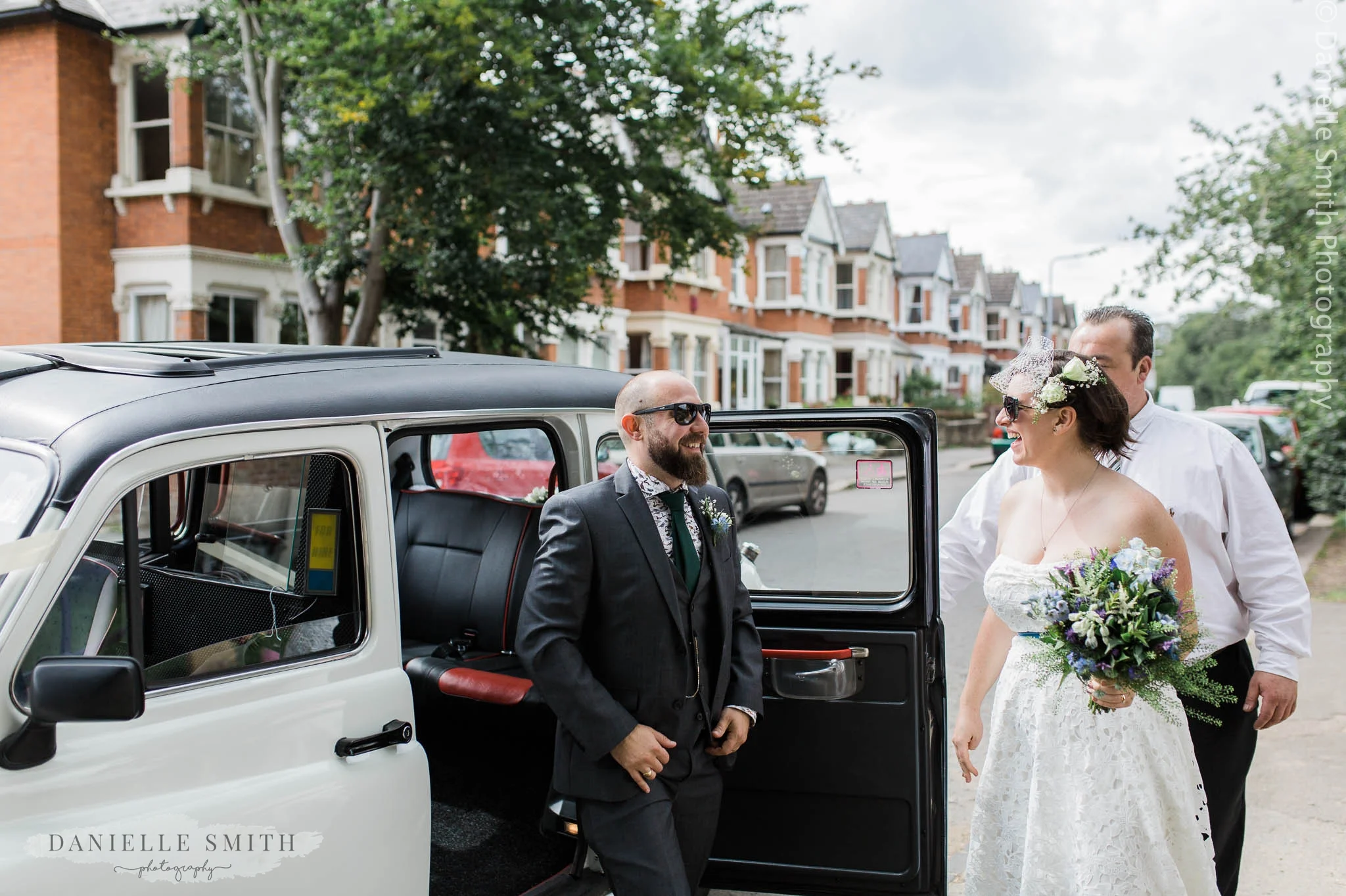 bride and groom getting out of white taxi