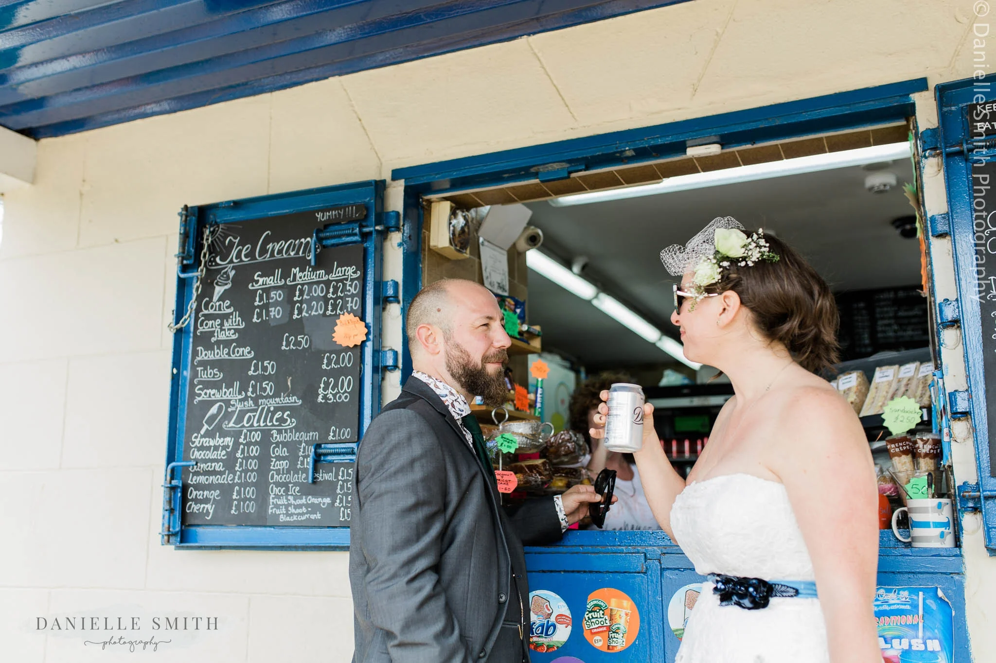 bride and groom buying can of coke from kiosk