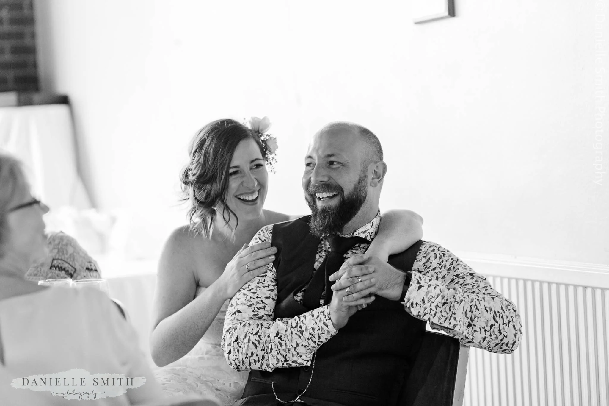 bride and groom laughing at speeches