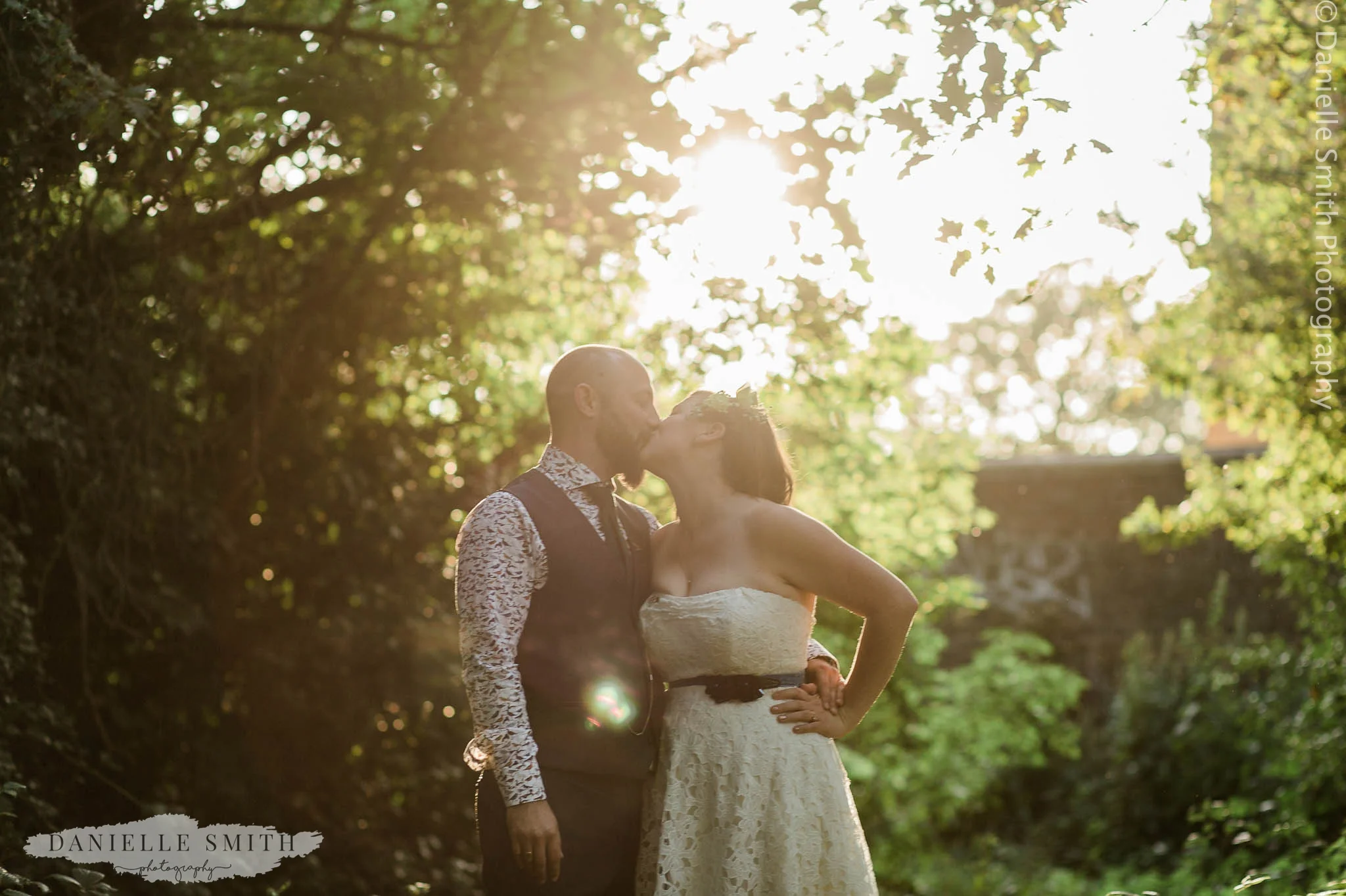 bride and groom kissing at sunset