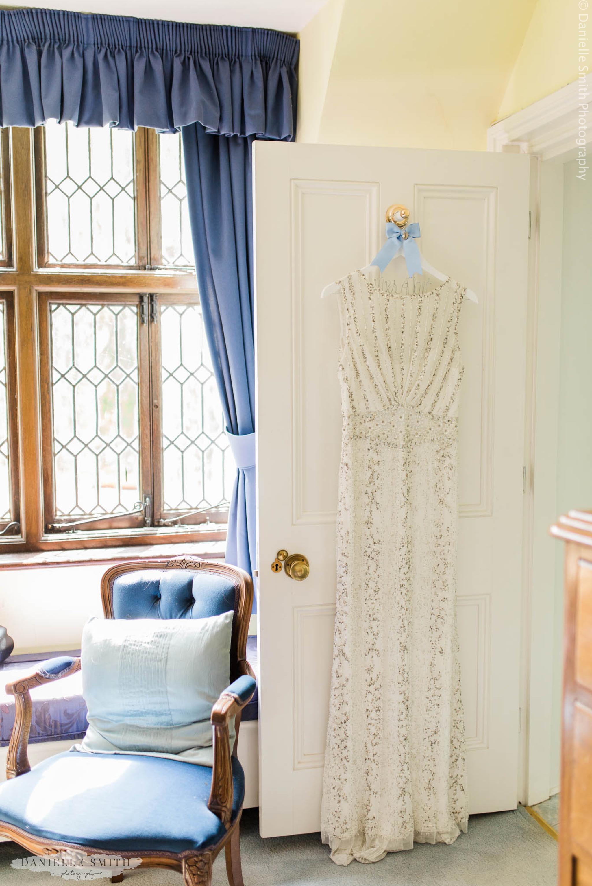 gatsby style beaded wedding dress hanging on door