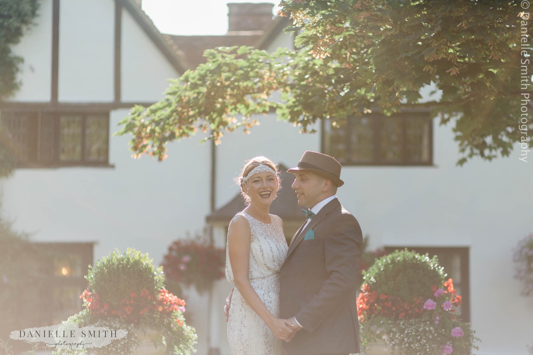 bride and groom smiling outside house at mangapp manor