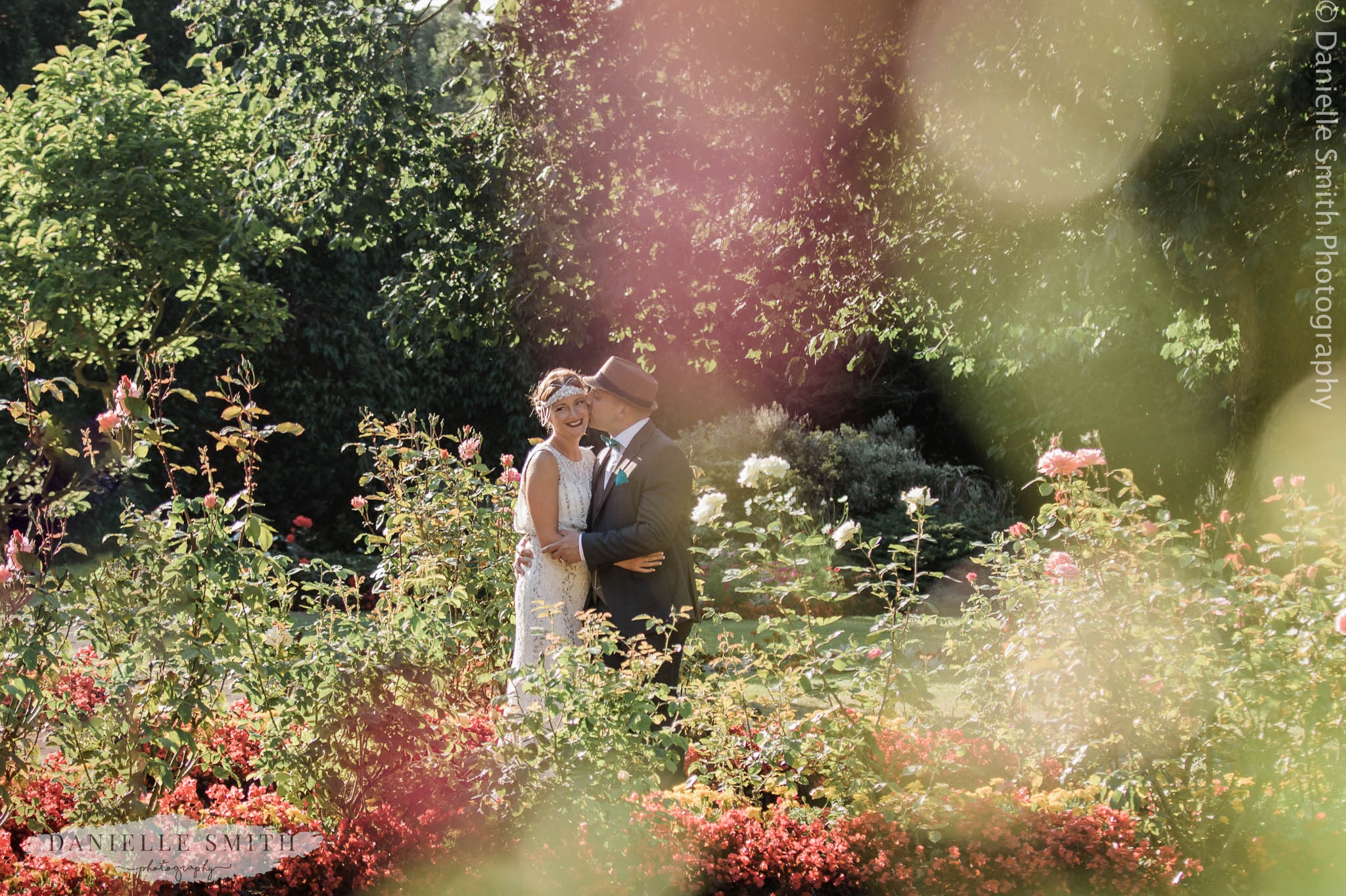 bgroom kissing bride through the flowers