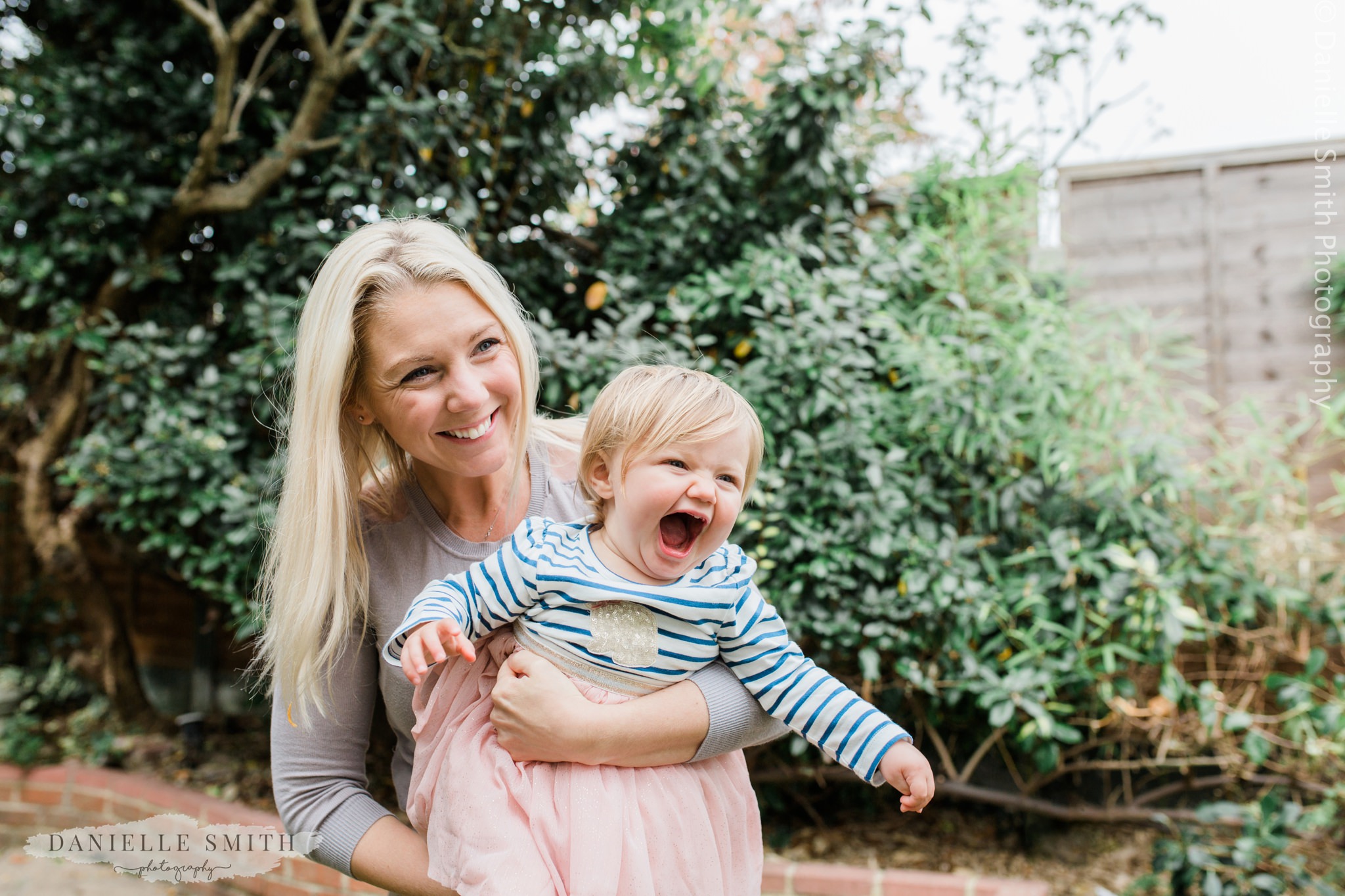 mother and baby laughing in the garden