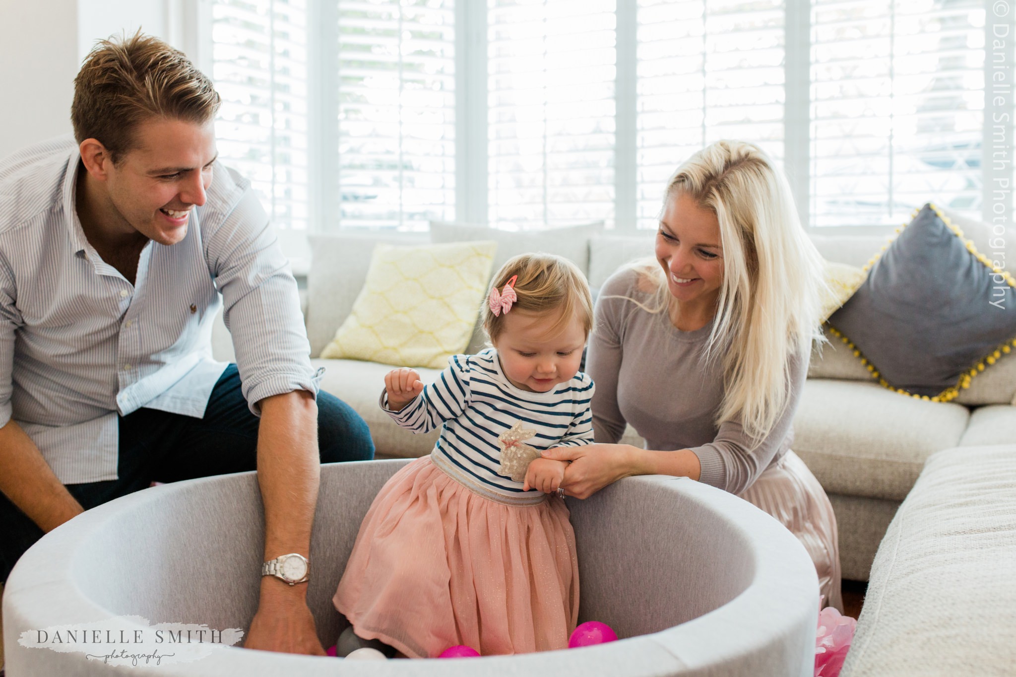 girl playing with ball pool with mum and dad