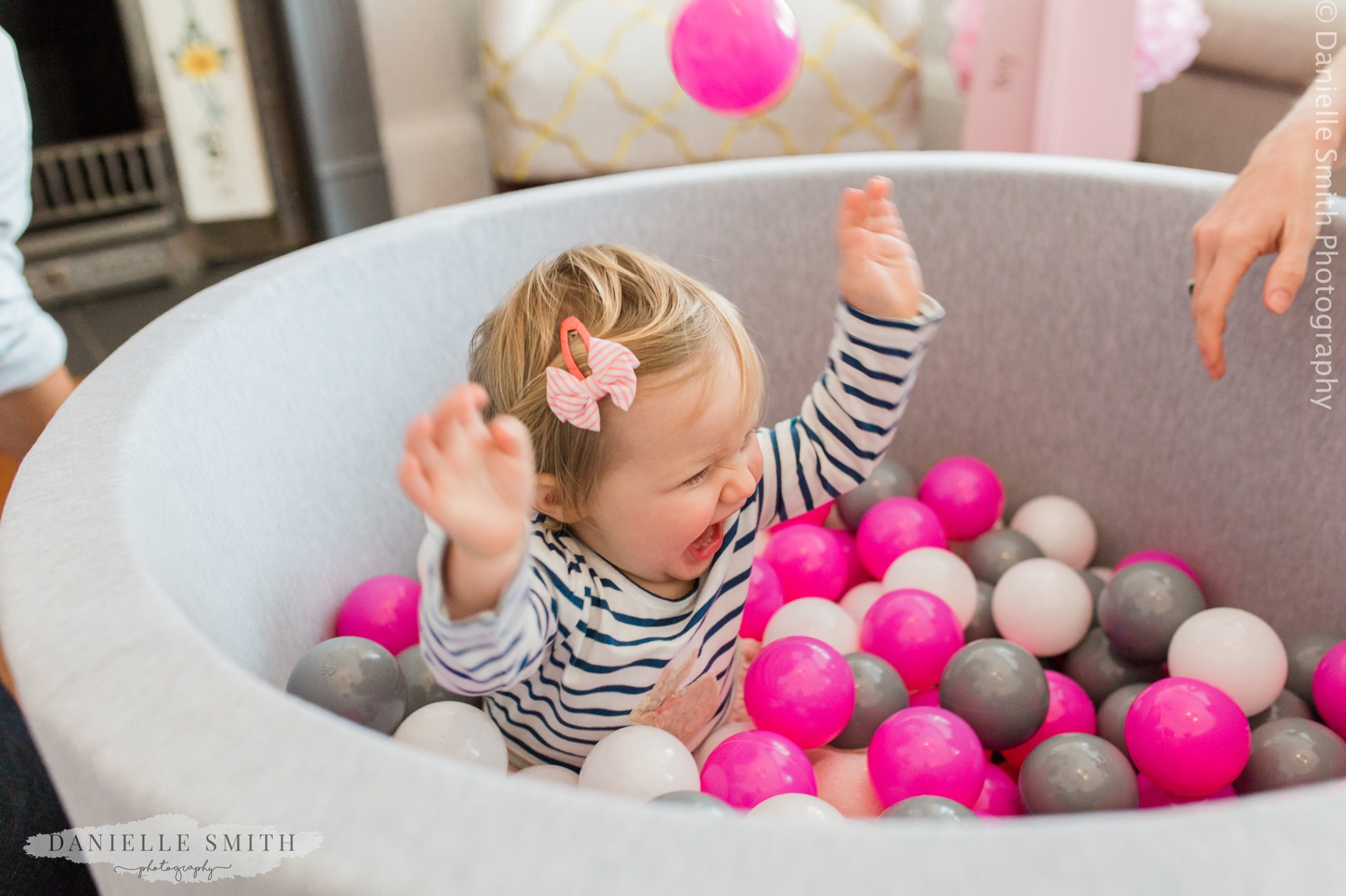 baby girl having fun splashing in her ball pool
