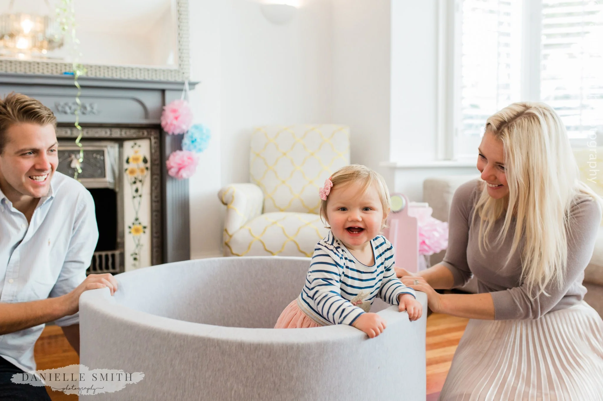 little girl on first birthday with ball pool