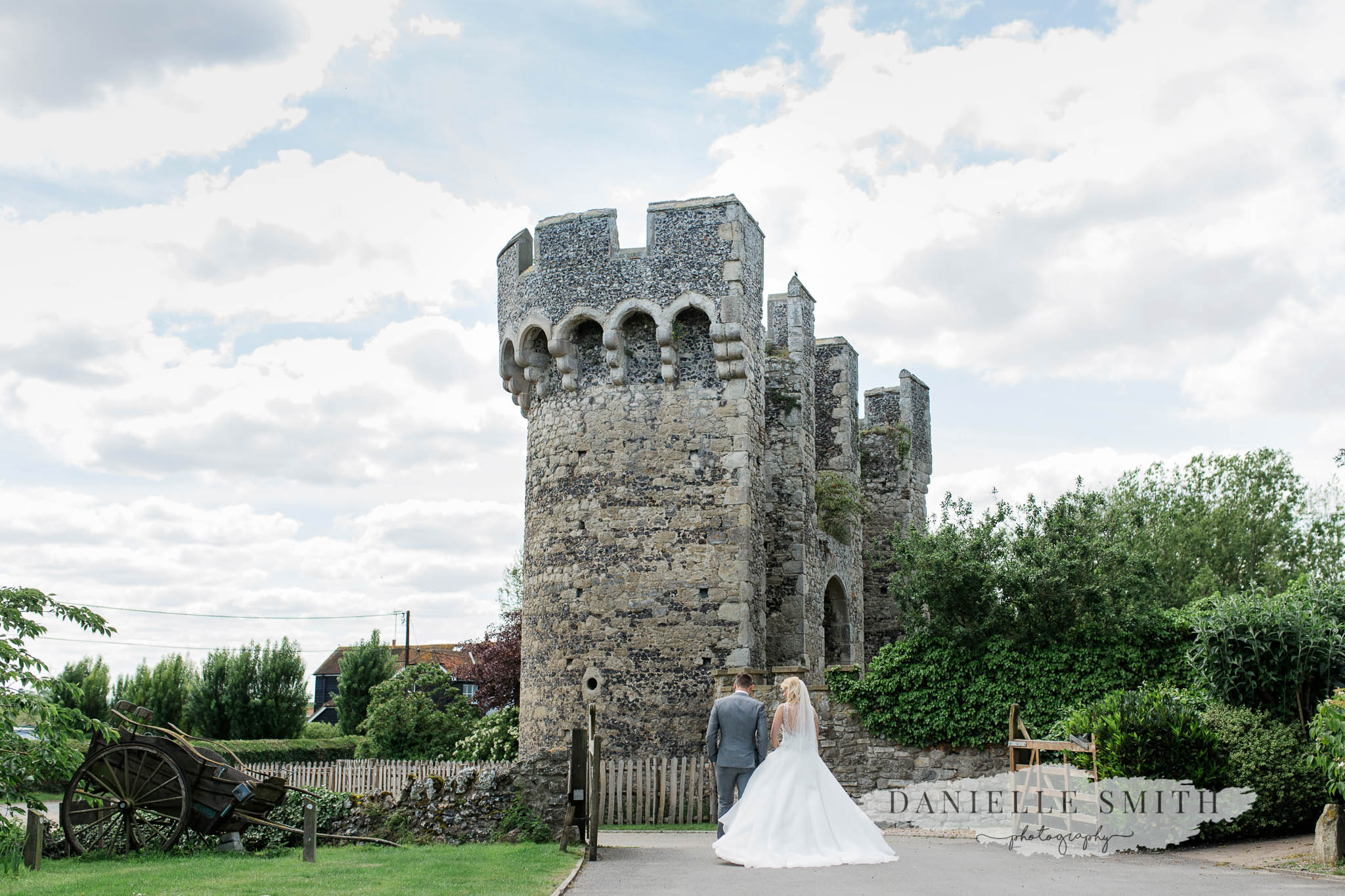 bride and groom walking towards castle - cooling castle barn