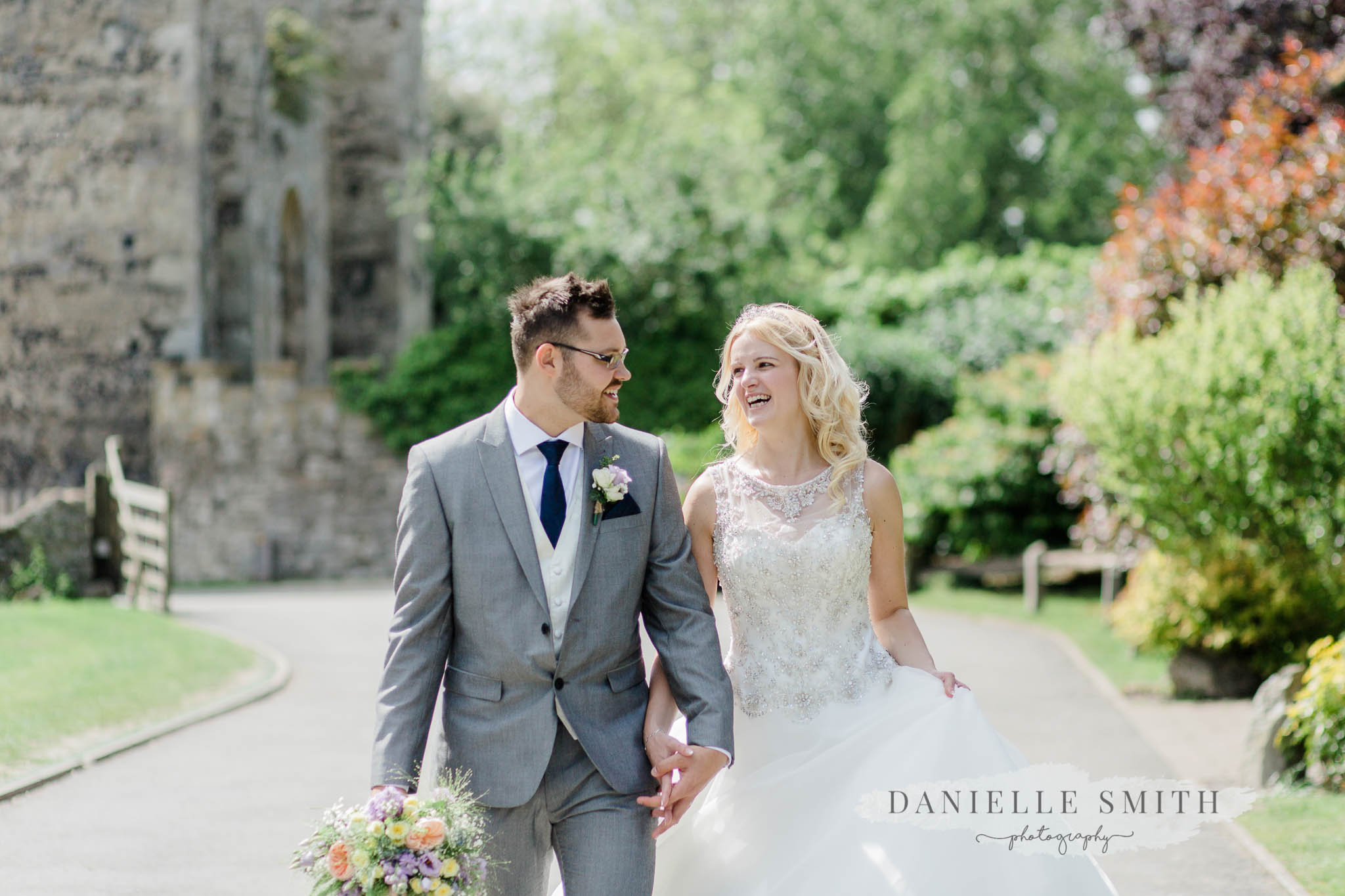 bride and groom walking and laughing - kent wedding photography