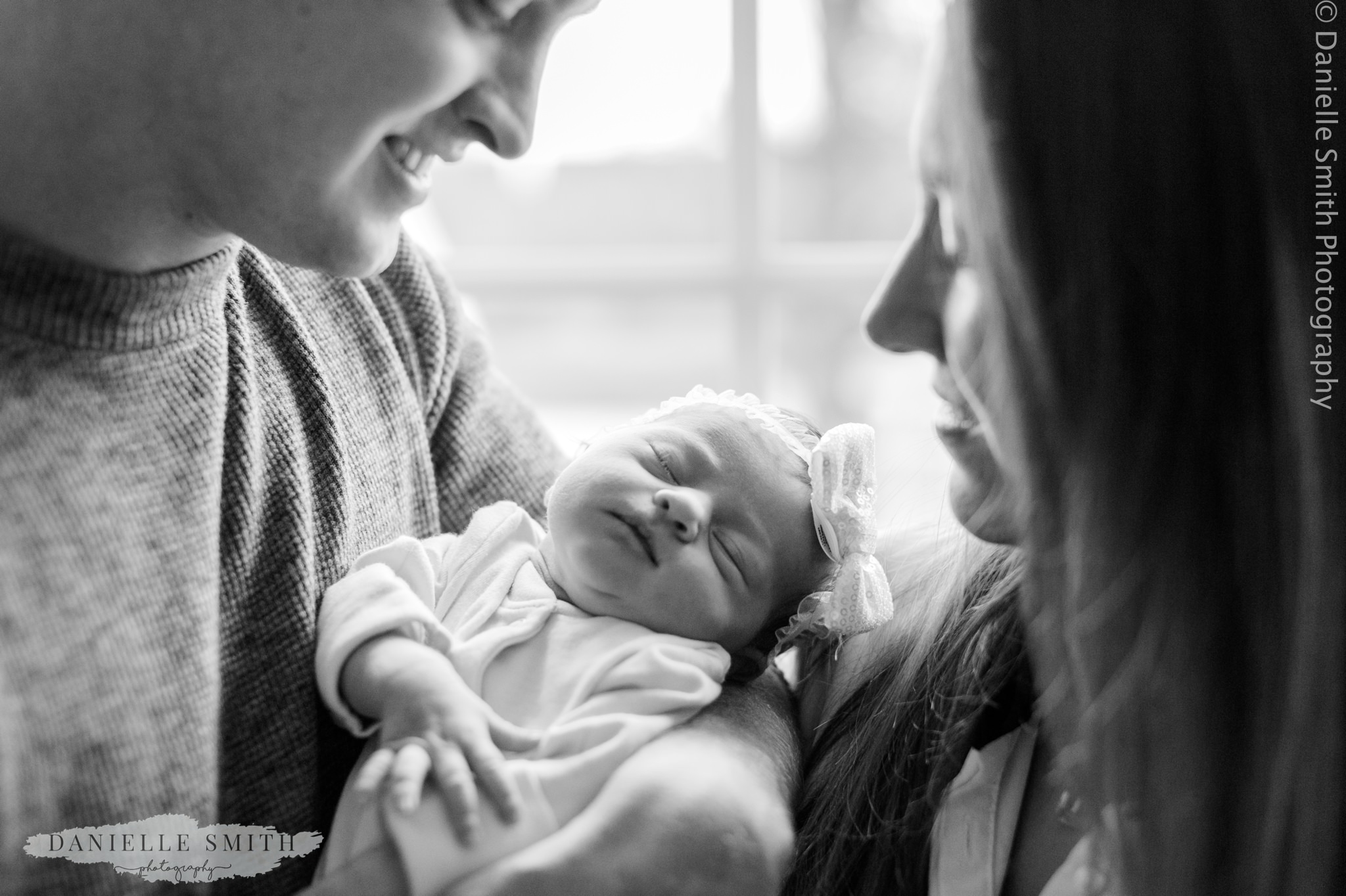 close up of mum and dad holding baby girl