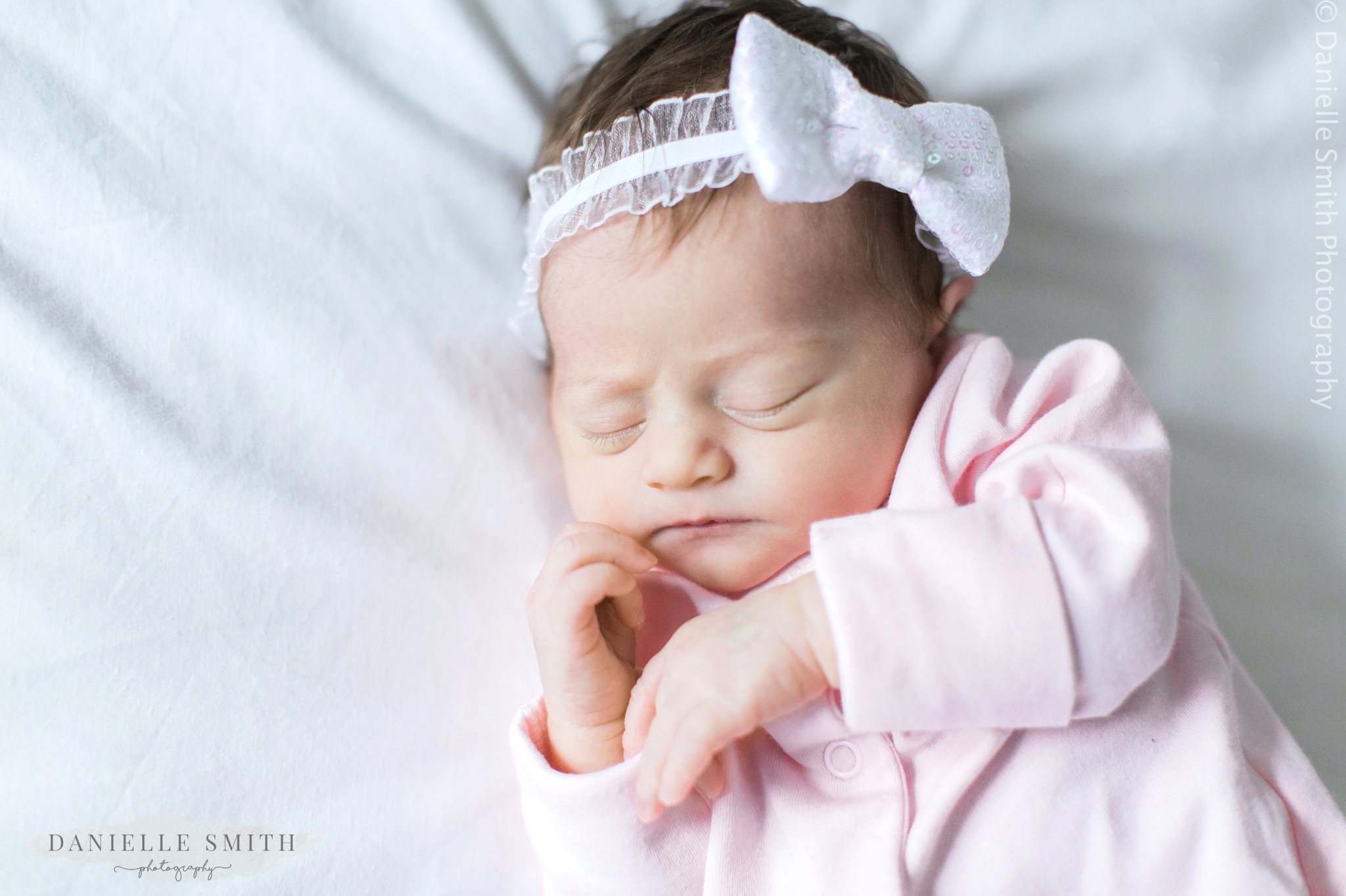 baby girl with white bow on head - newborn lifestyle photography