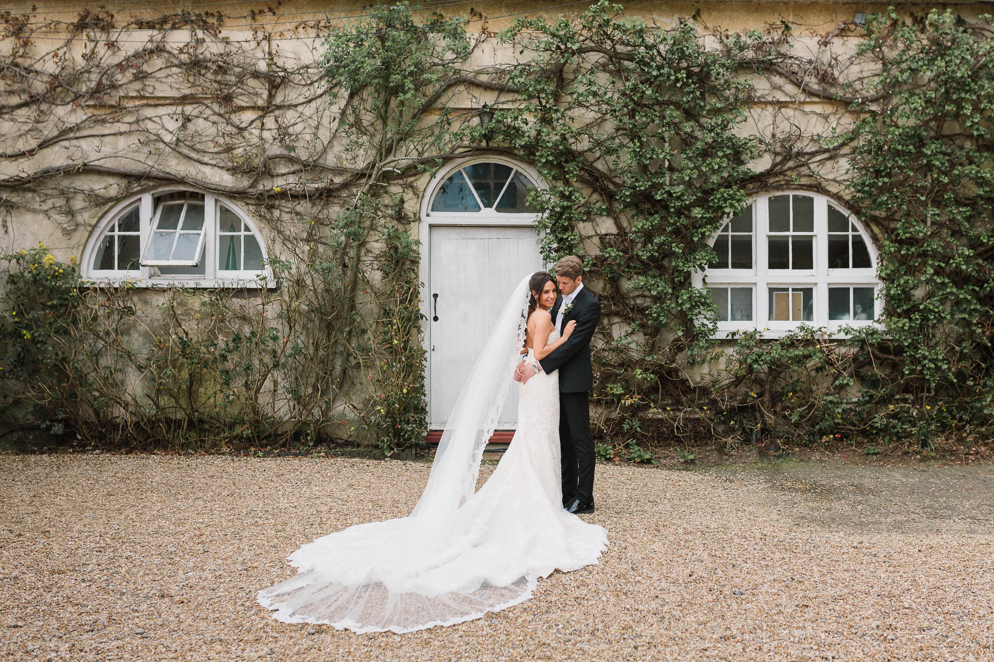 bride and groom in front of coach house at northbrook park wedding venue