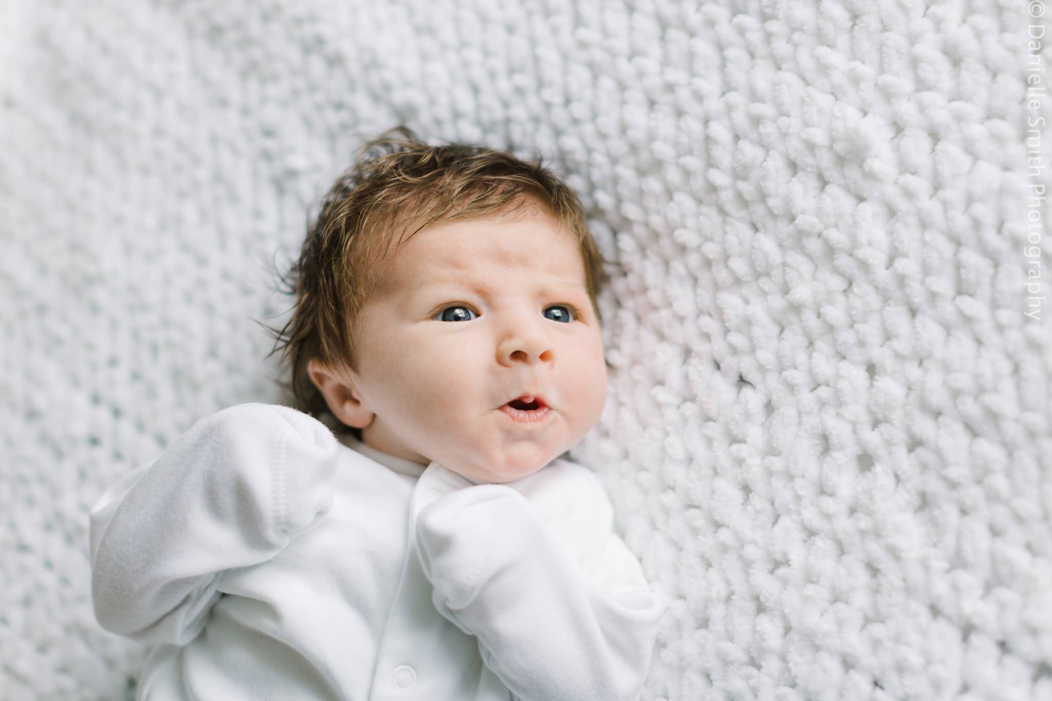 newborn baby pulling funny face