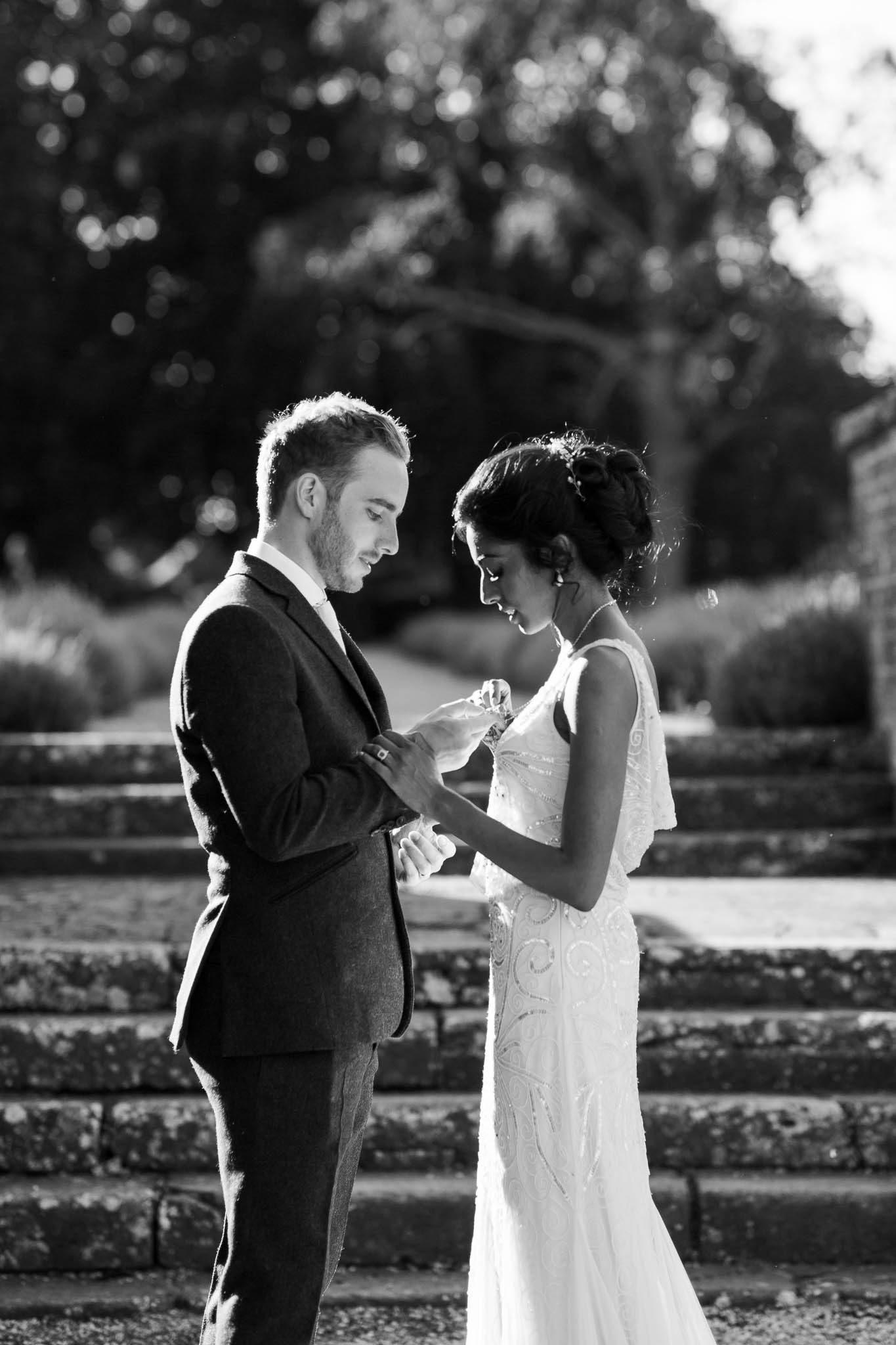 groom looking at brides necklace