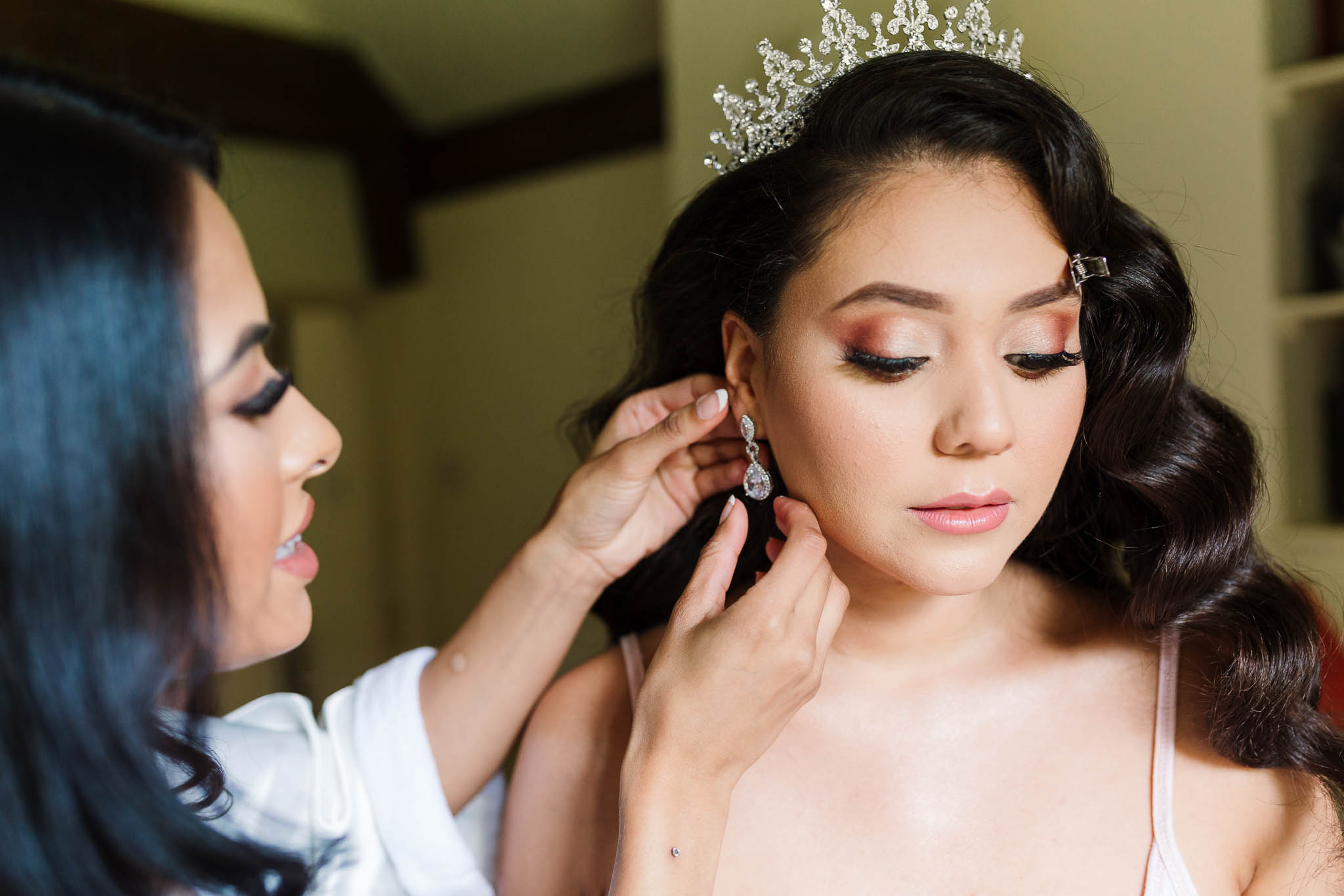 bridesmaid helping bride with earrings