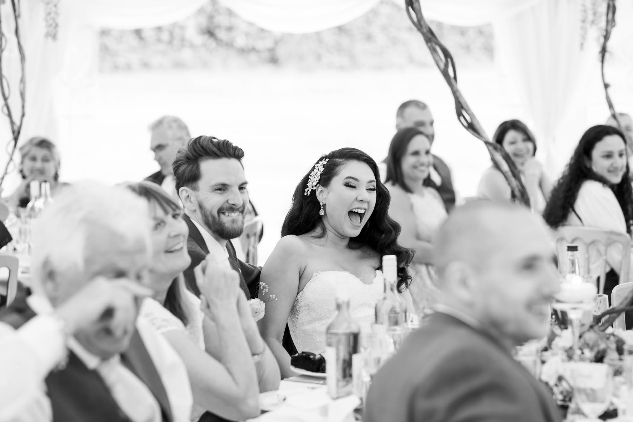 bride and groom laughing at speeches