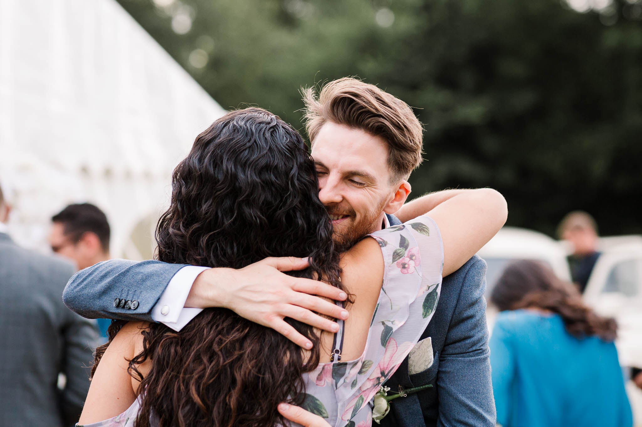 groom hugging guest at fun and relaxed wedding