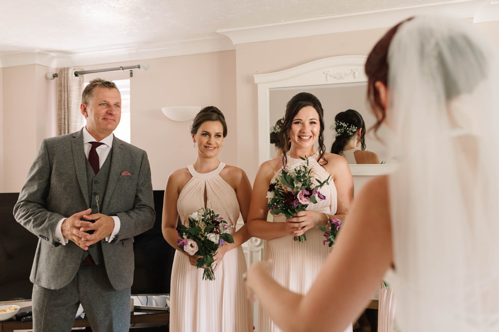 bridesmaids and Dad seeing bride in her dress