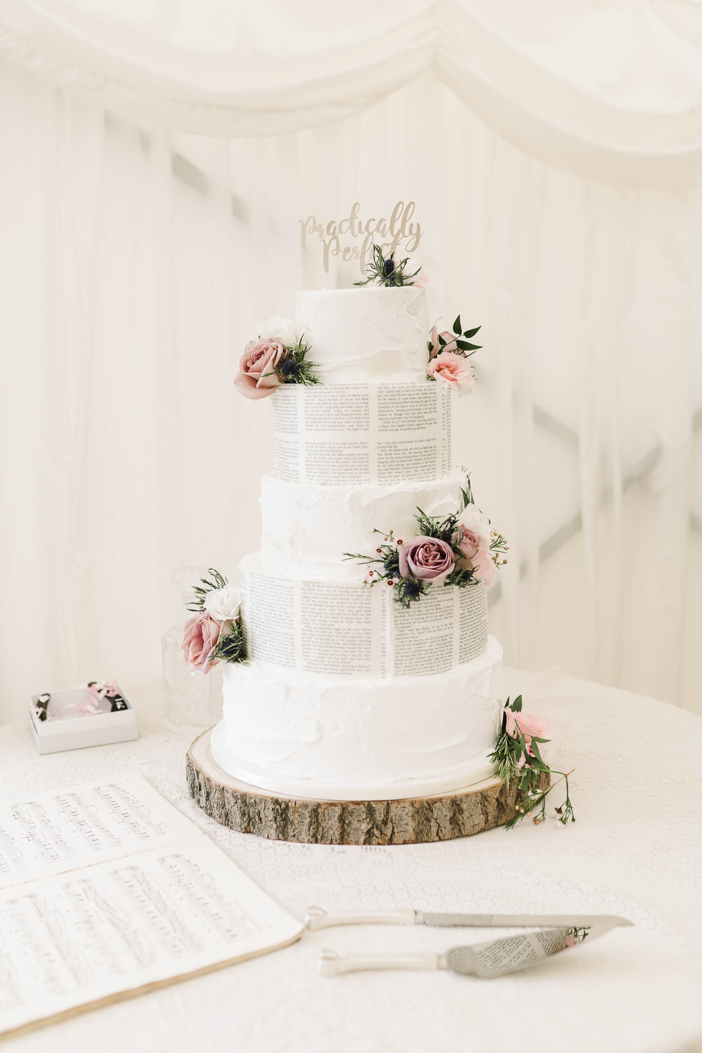 white wedding cake with book pages