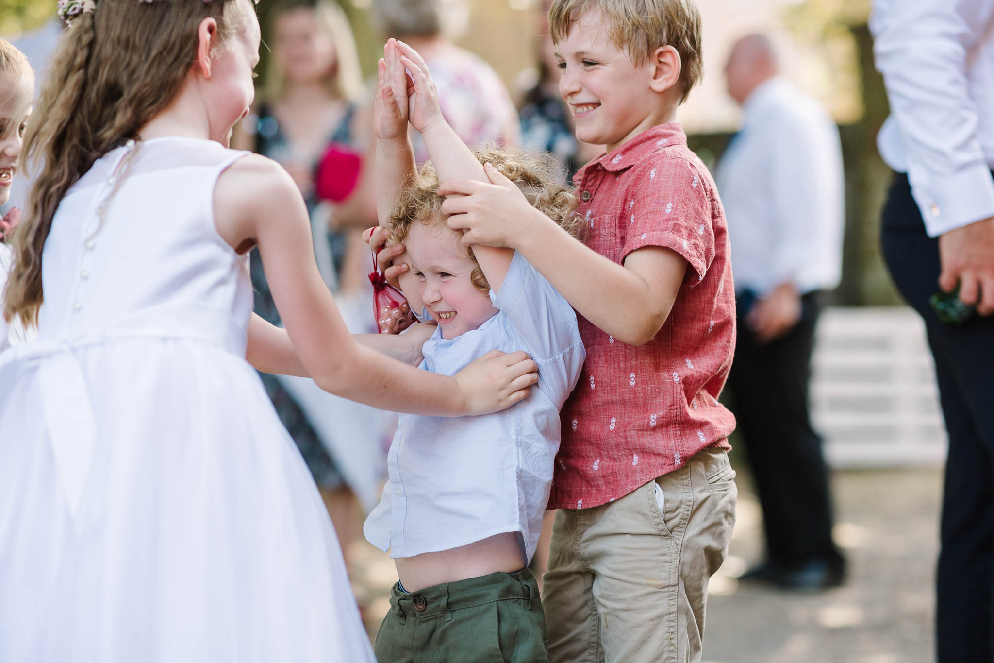kids tickling each other at wedding