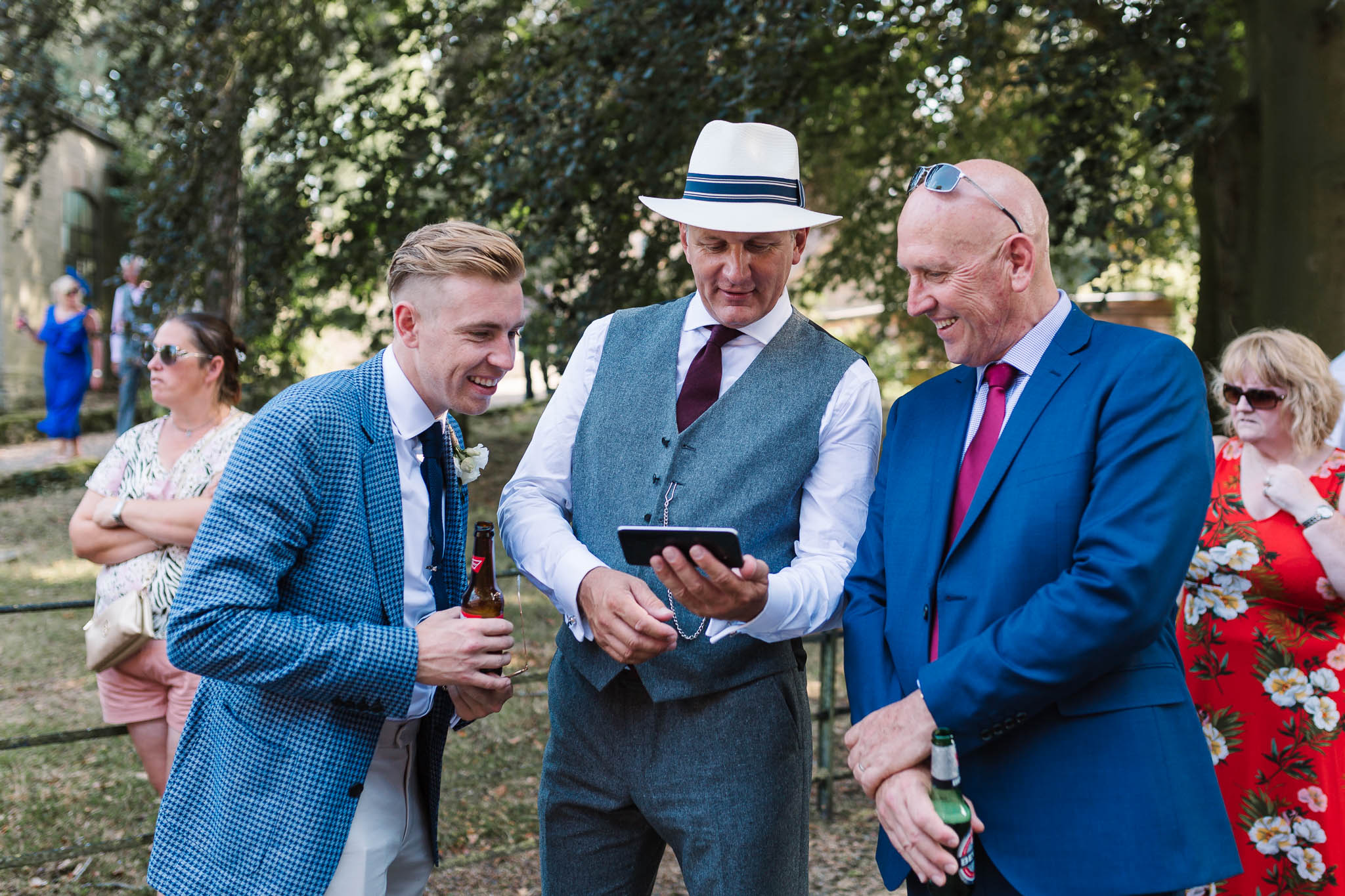 wedding guests laughing at phone