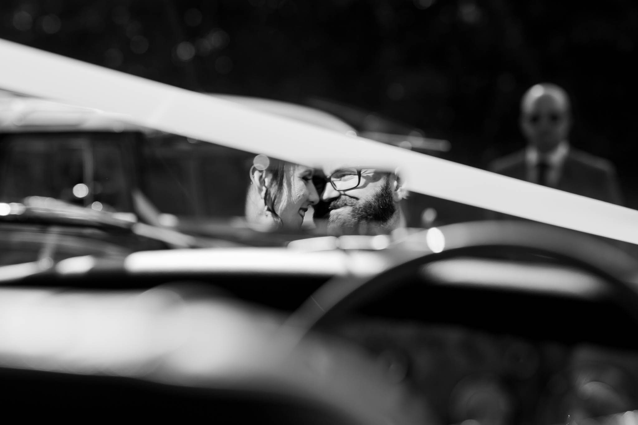 bride and groom in mirror of vintage car