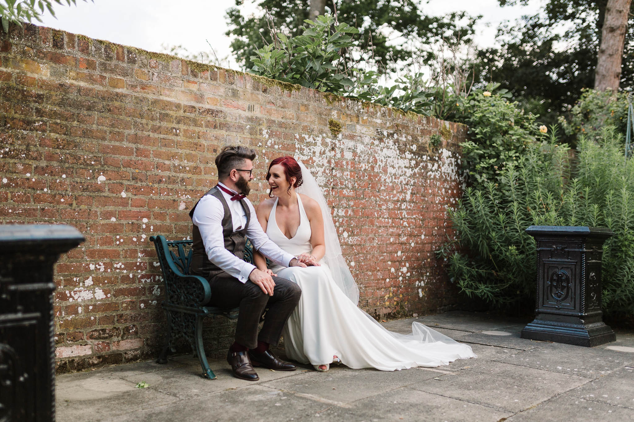 bride and groom sitting on bench at swarling manor