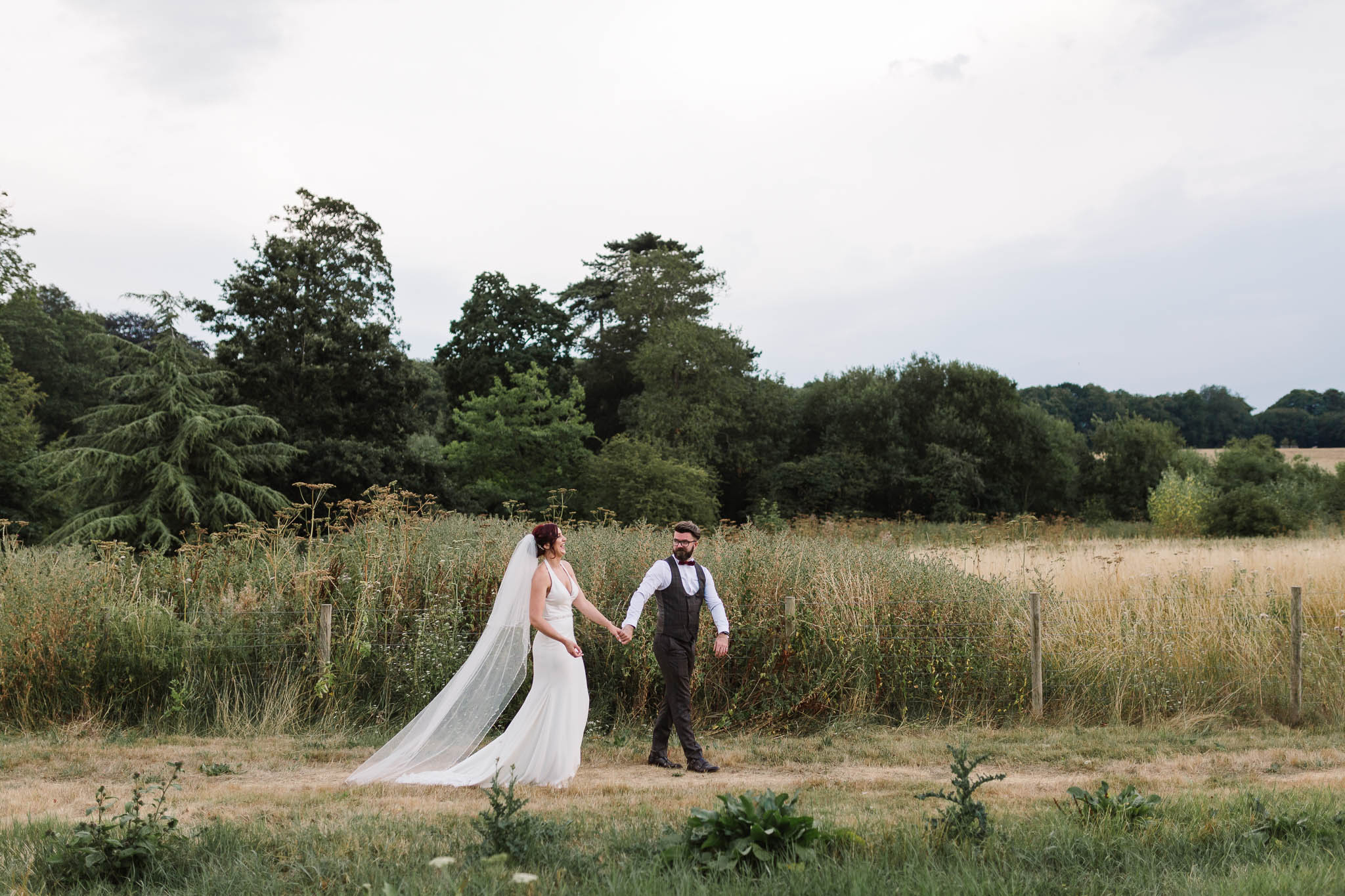 bride and groom walking through countryside