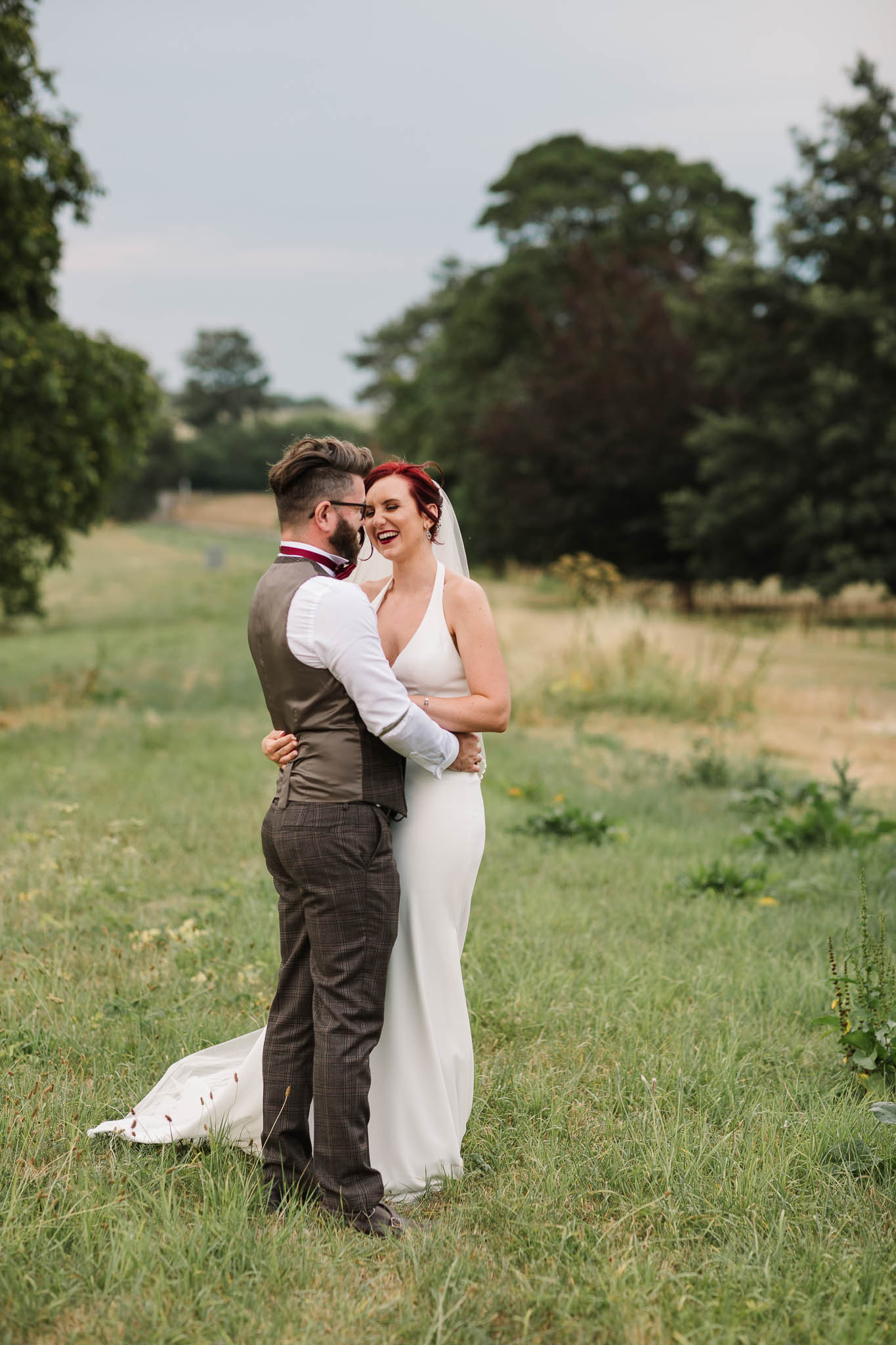 bride and groom laughing at english country wedding
