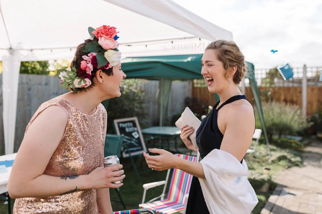 ride and bridesmaid laughing - LANGTONS HOUSE WEDDING AND CHILLED GARDEN RECEPTION AT HOME