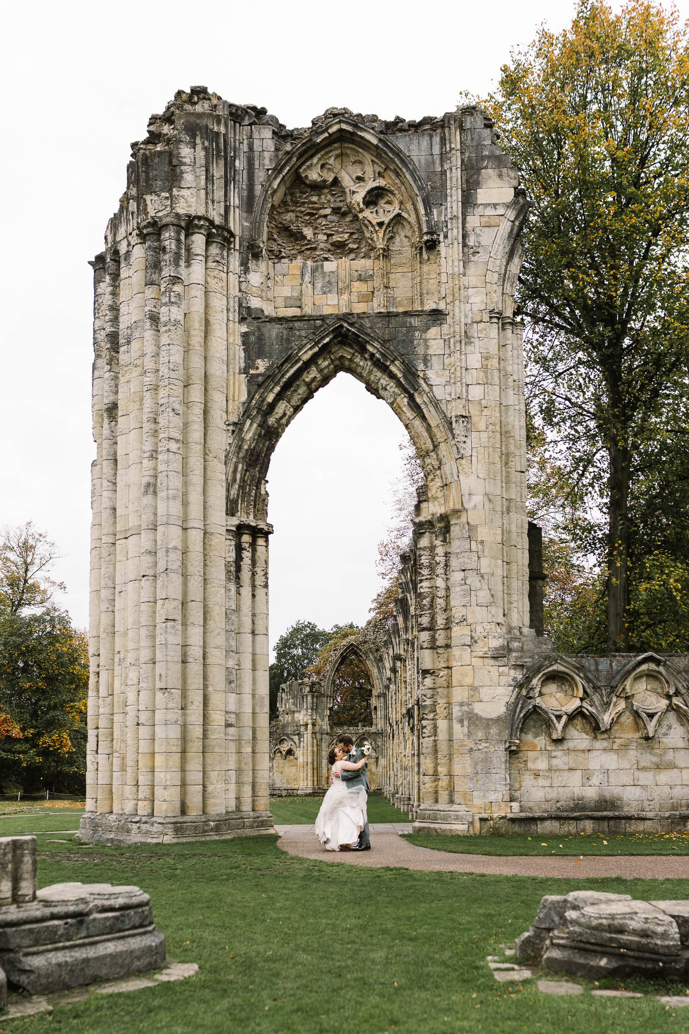 bride and groom hugging by the ruins at hospitium york
