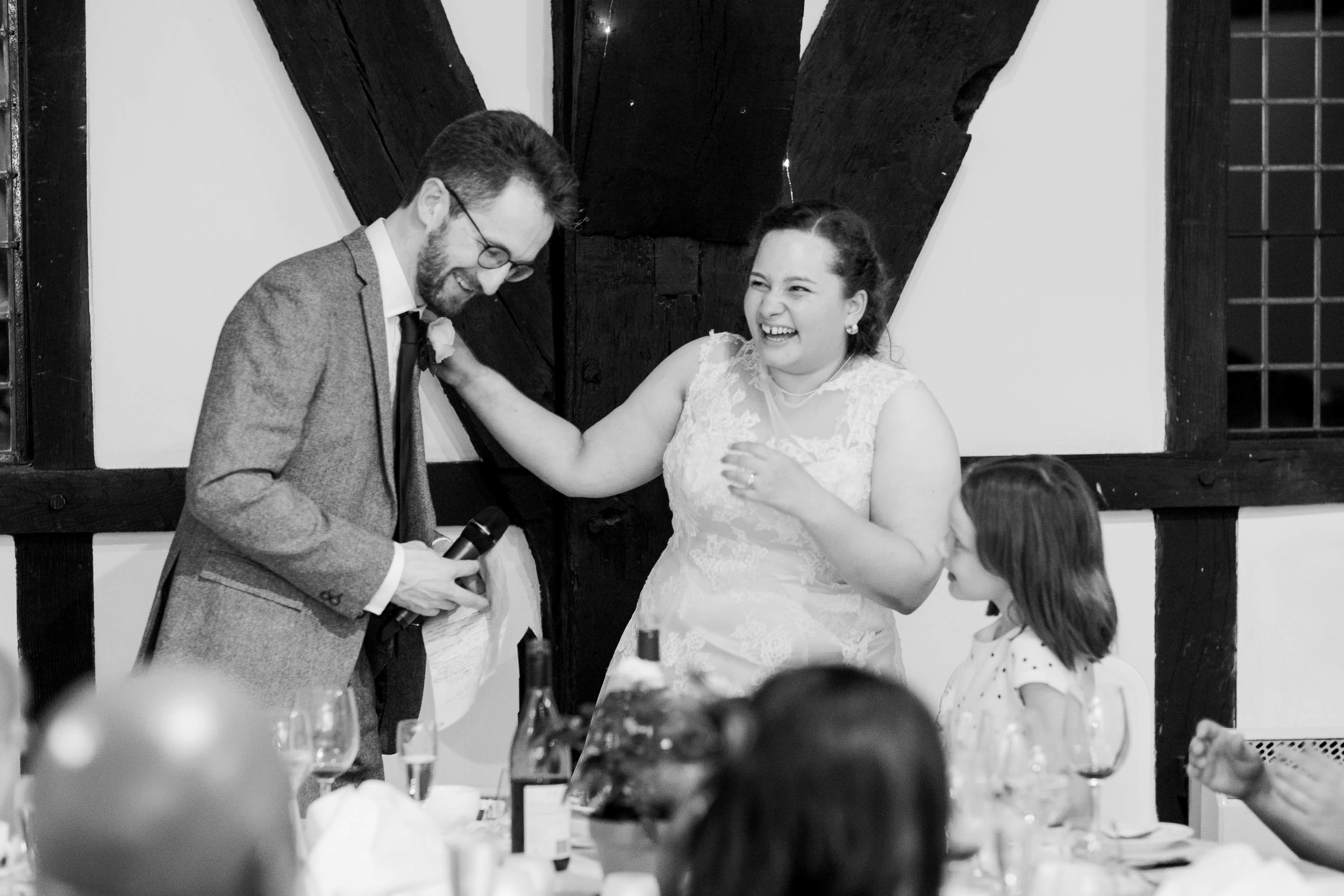 bride and groom laughing as they give speech