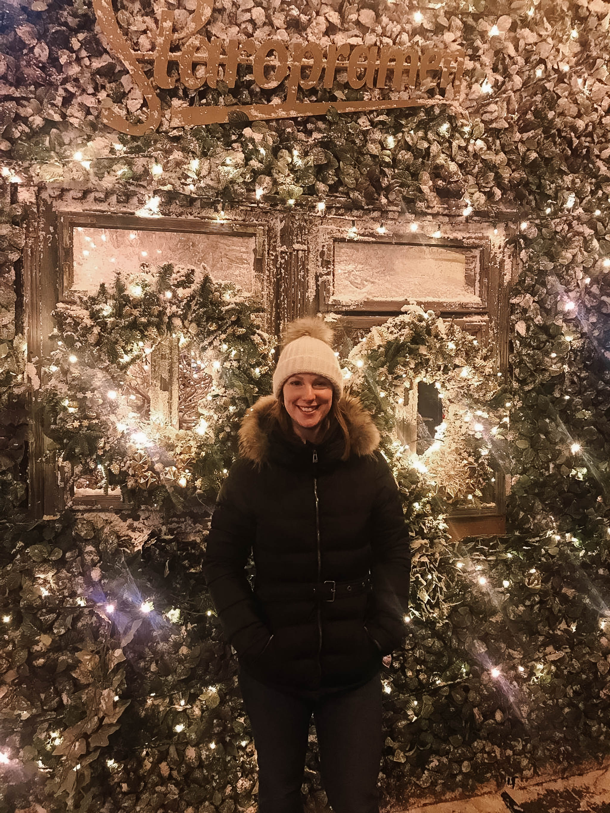 standing by christmas lights on market