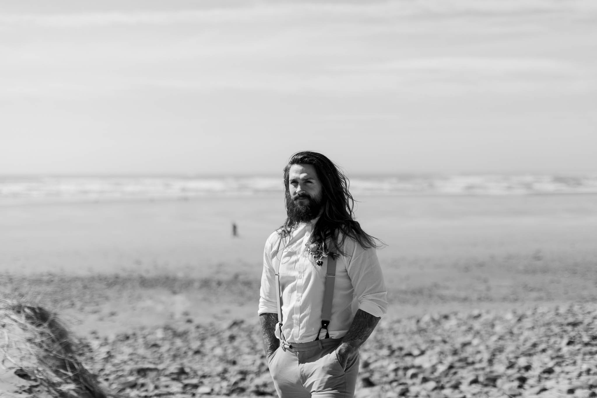groom standing on the beach