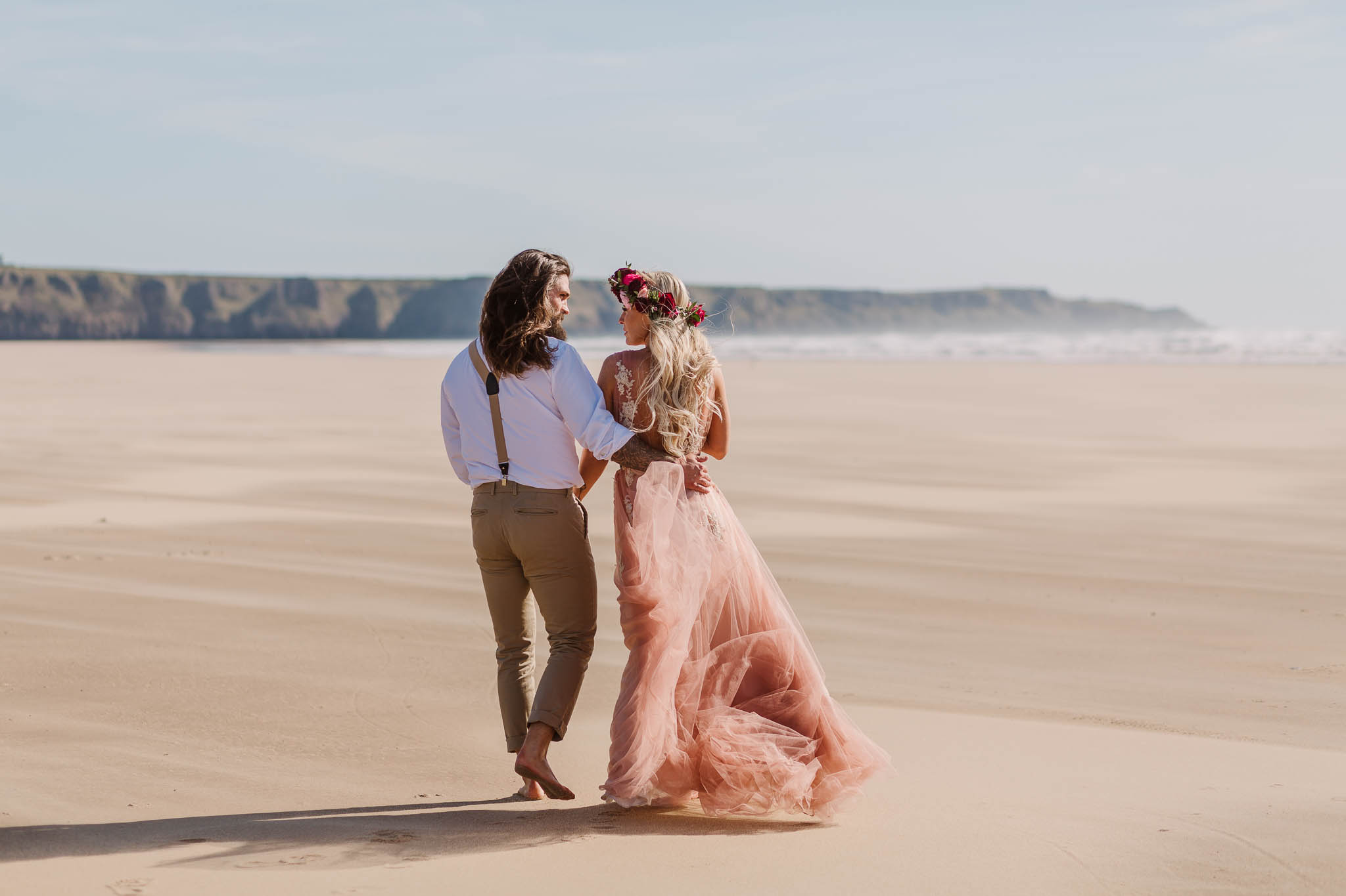 bride and groom walking on the beach