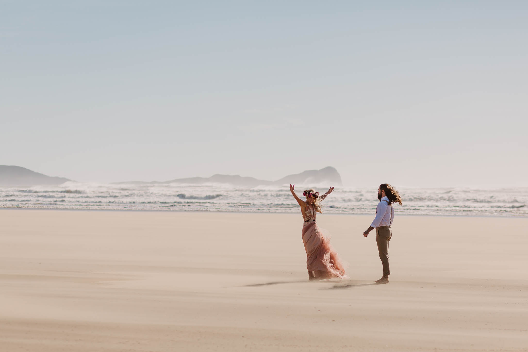 bride and groom having fun on the beach