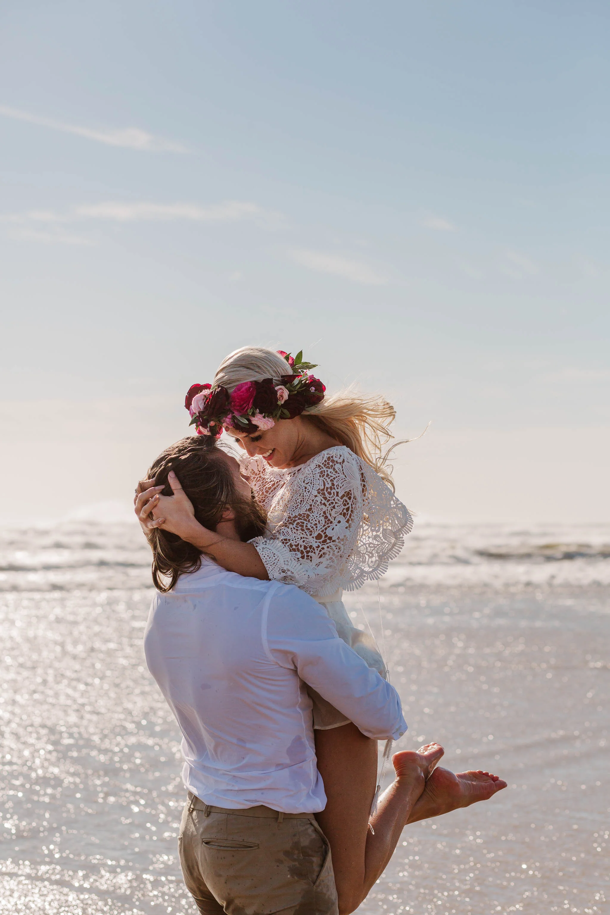 groom lifting up the bride in the sea