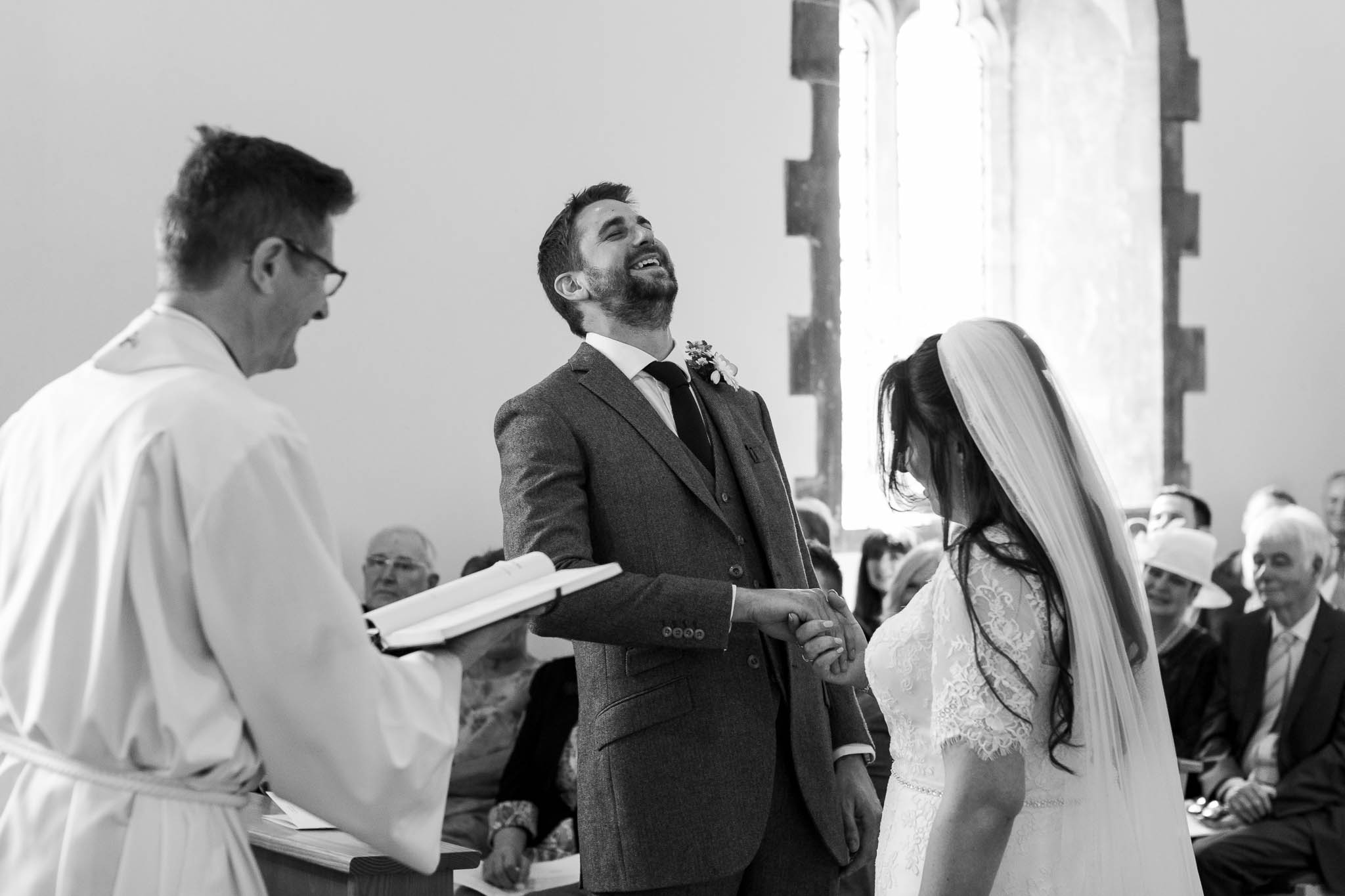 groom laughing during vows