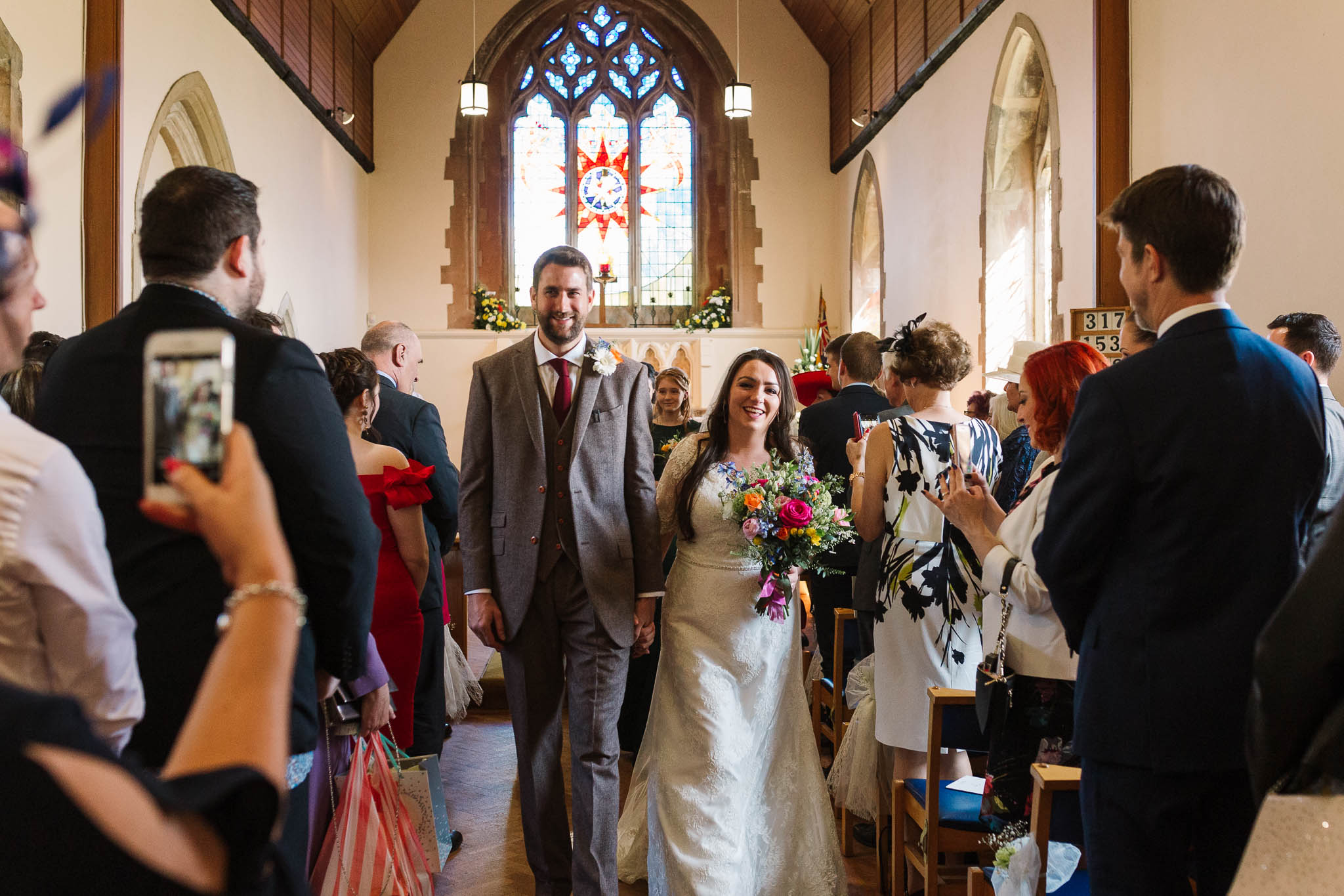 bride and groom walking down aisle smiling