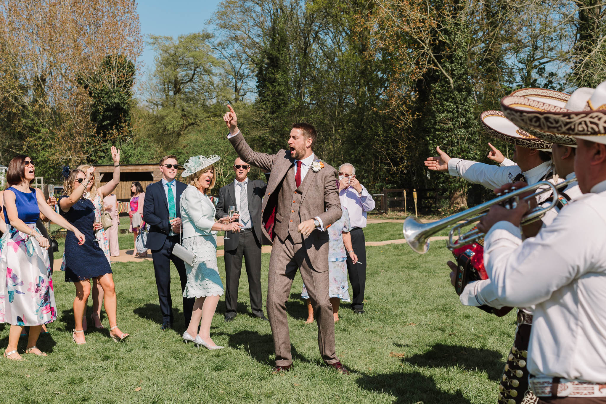 groom and wedding guests dancing to mariachi band