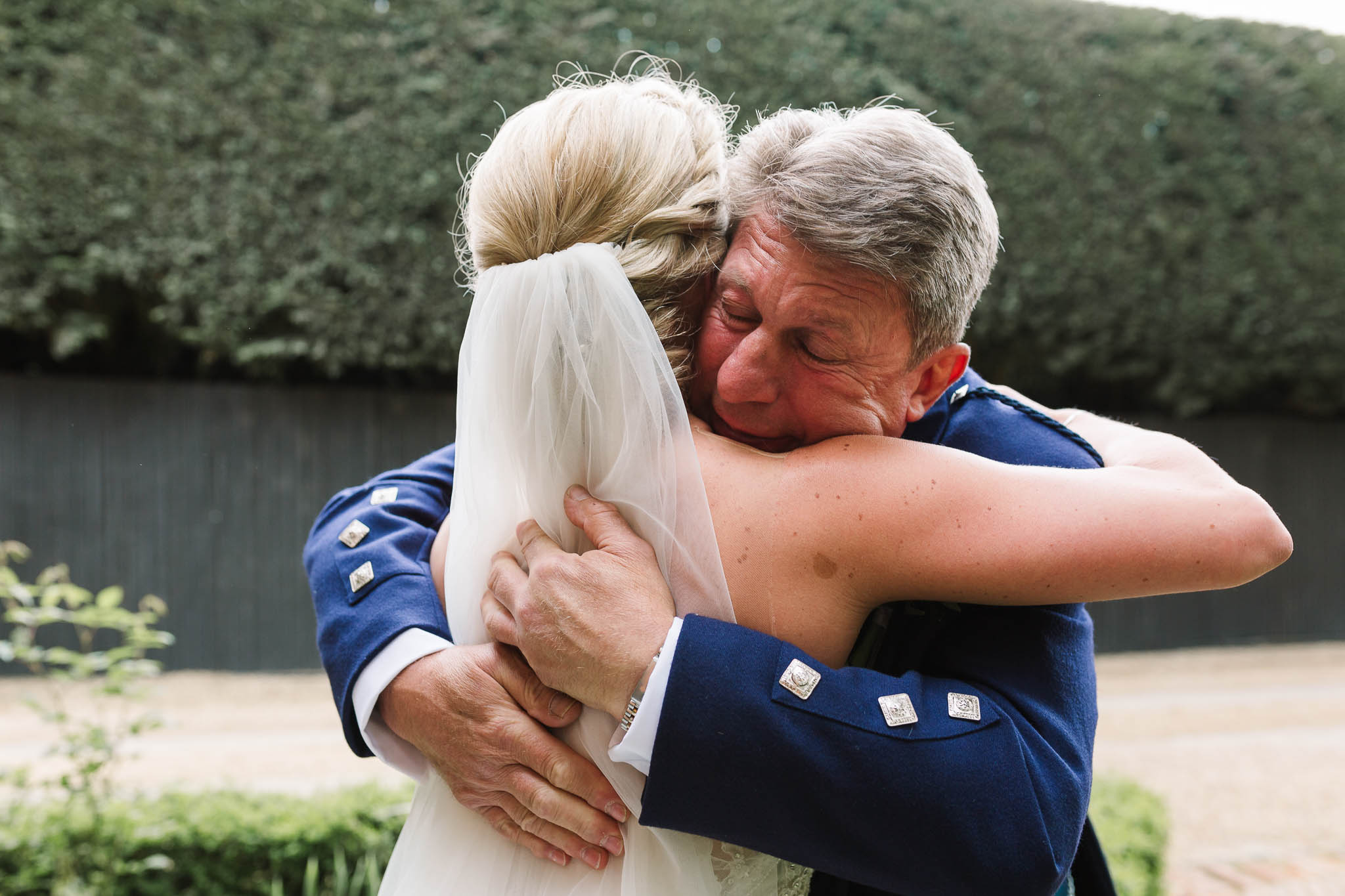 father of bride hugging daughter