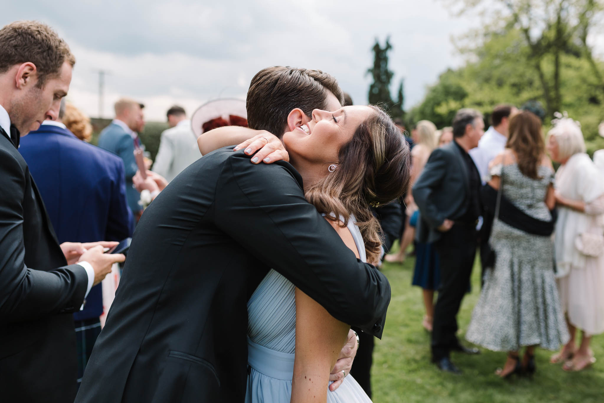 groom hugging bridesmaid