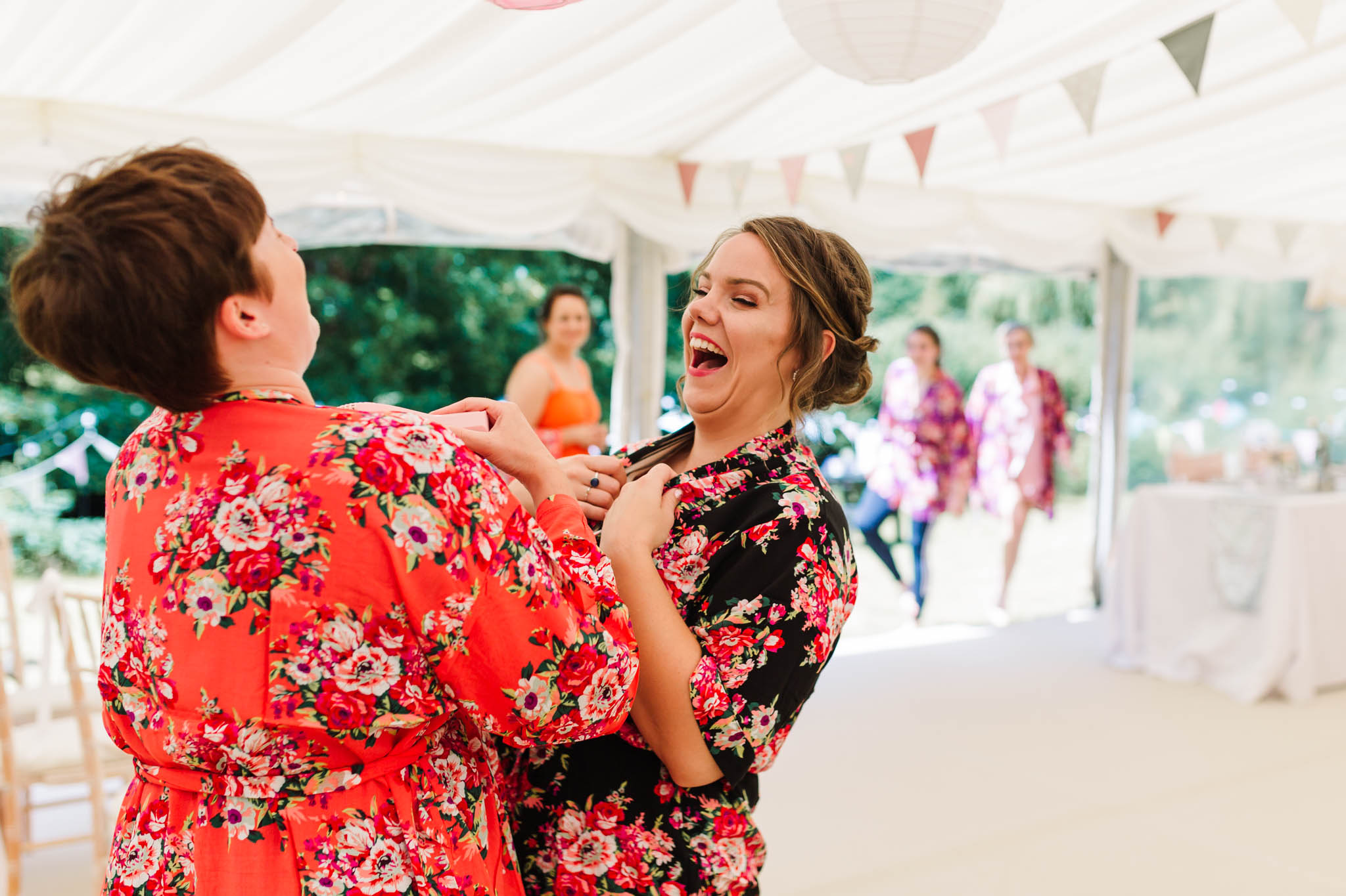 bridesmaids laughing in floral robes