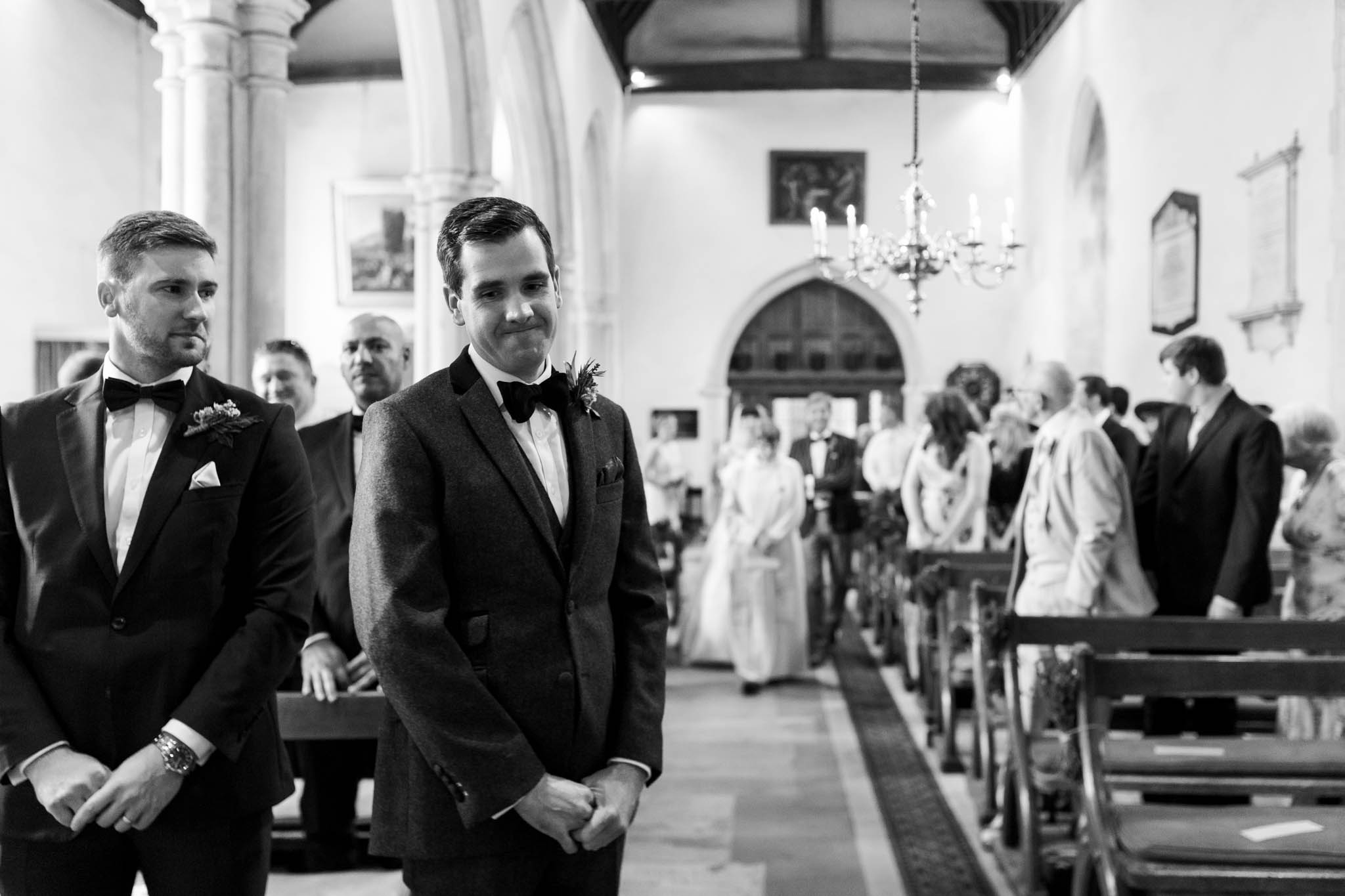groom waiting as bride walks down aisle