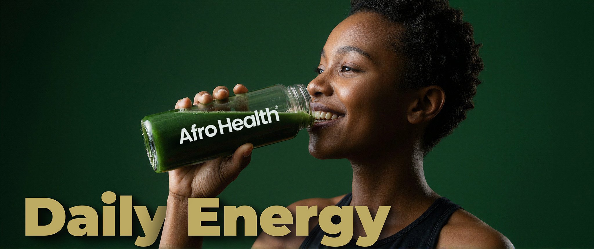 A woman with short curly hair drinking a green juice from a glass with 'AfroHealth' written on it, against a dark green background. Supplement hero image
